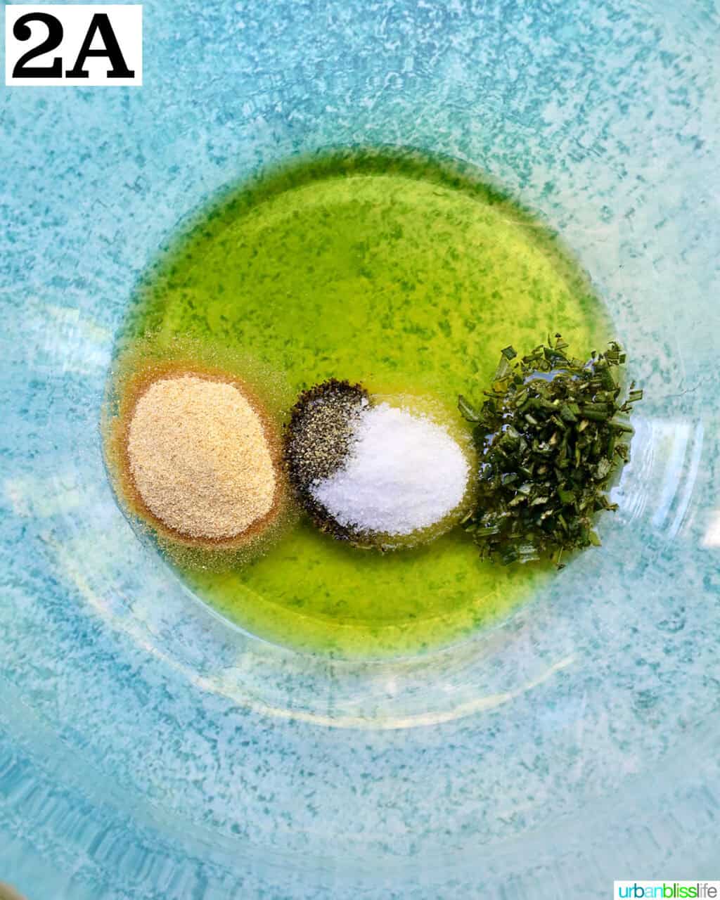 ingredients to make olive oil herb mixture in a glass bowl.