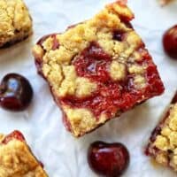 cherry crumble bars surrounded by cherries.