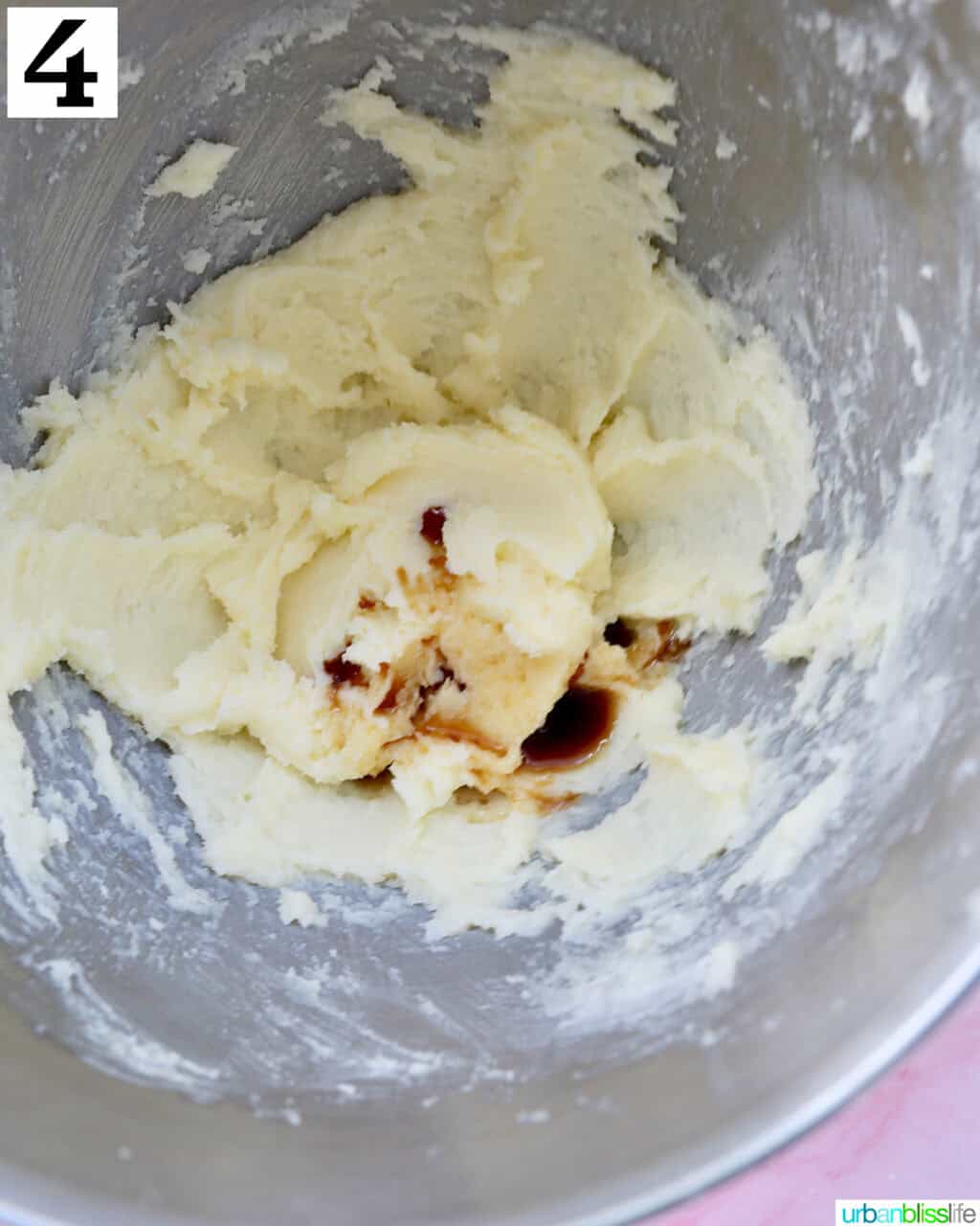 vanilla added to creamed butter and sugar in a stainless steel bowl.