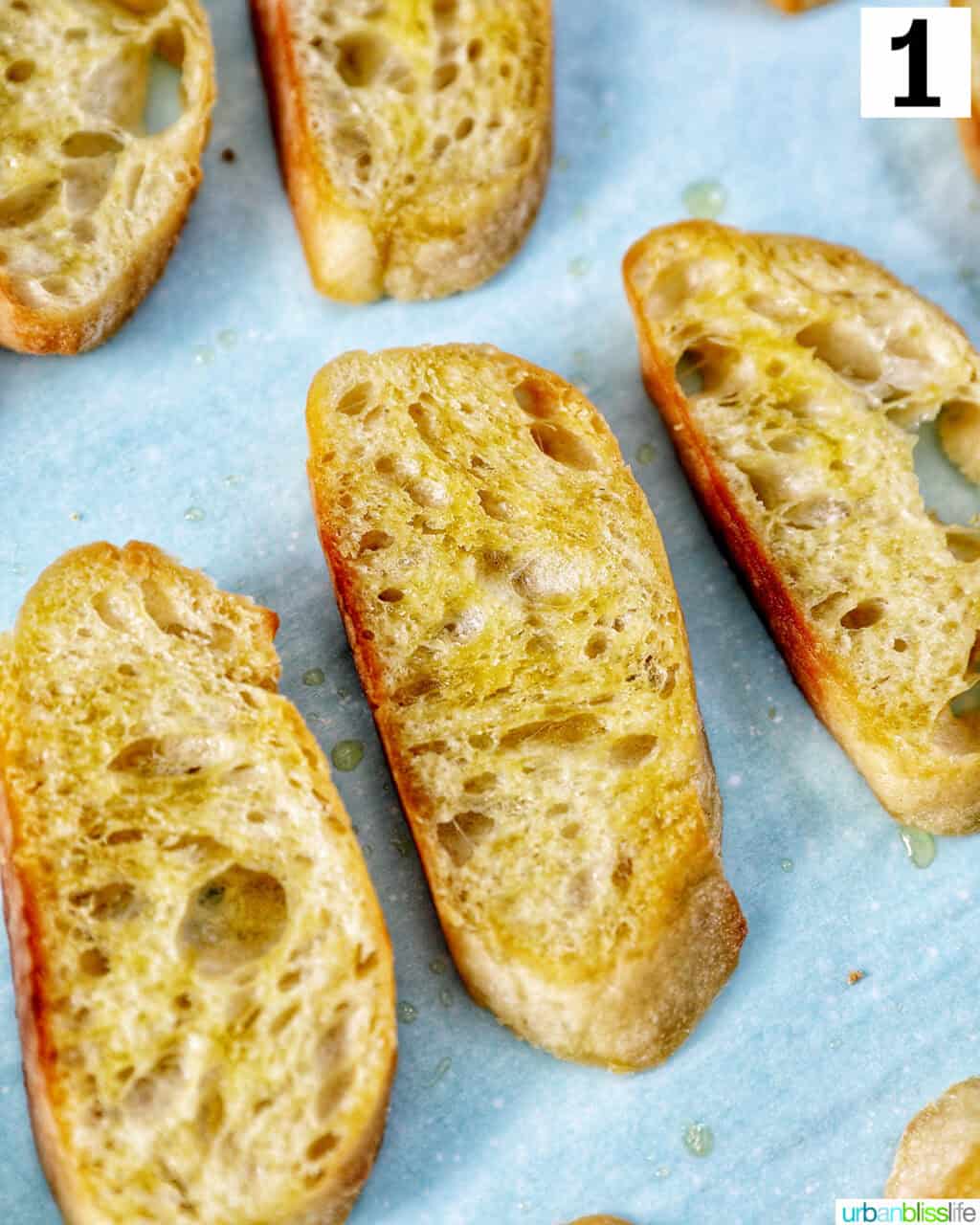 closeup of a few baguette slices on parchment paper.