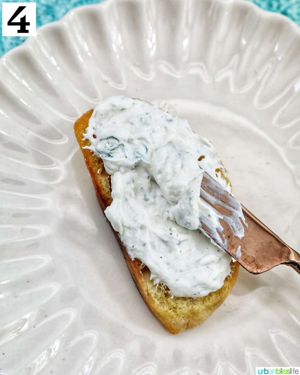 single crostini on a plate with cream cheese.