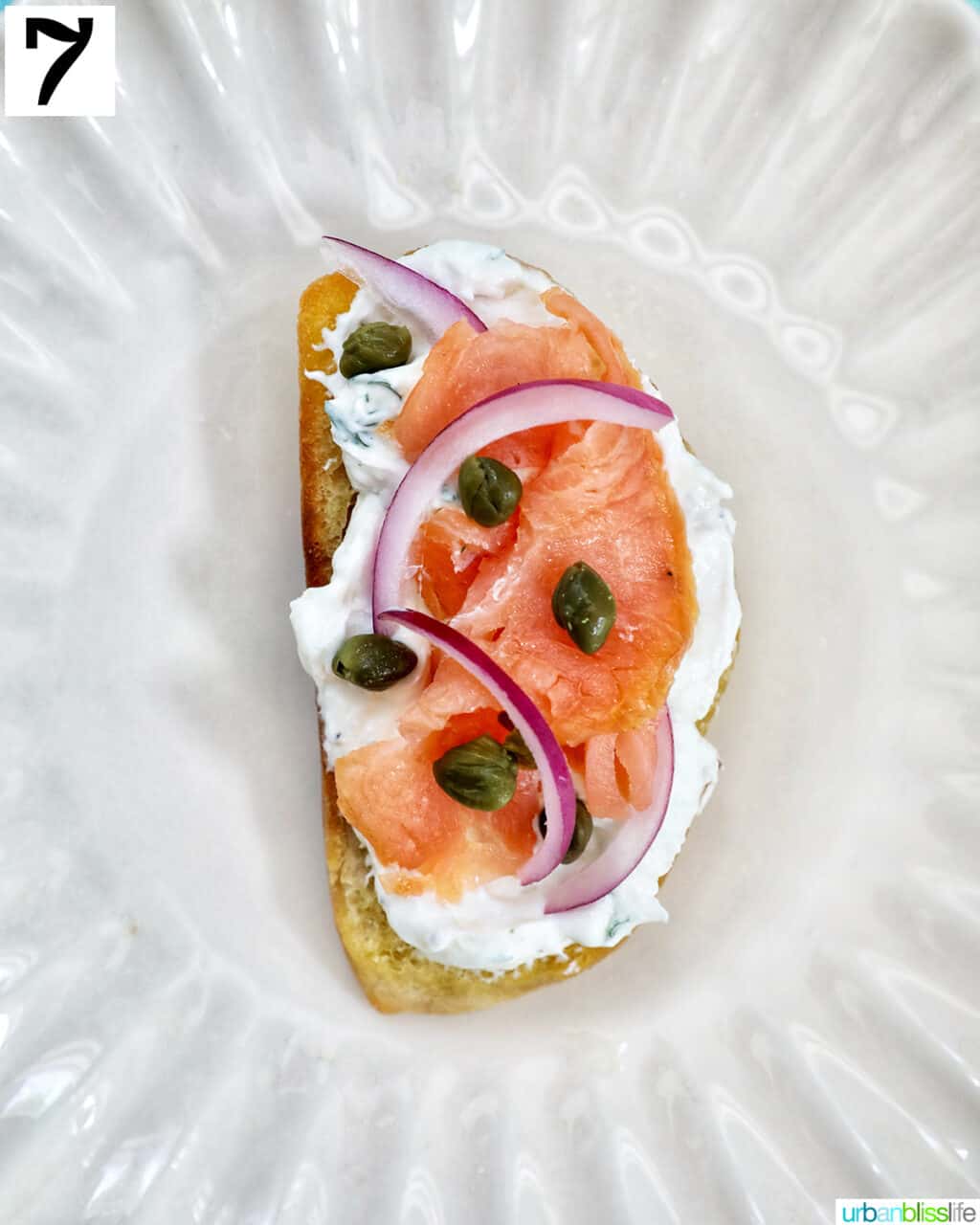 single crostini al salmone on a plate with capers.