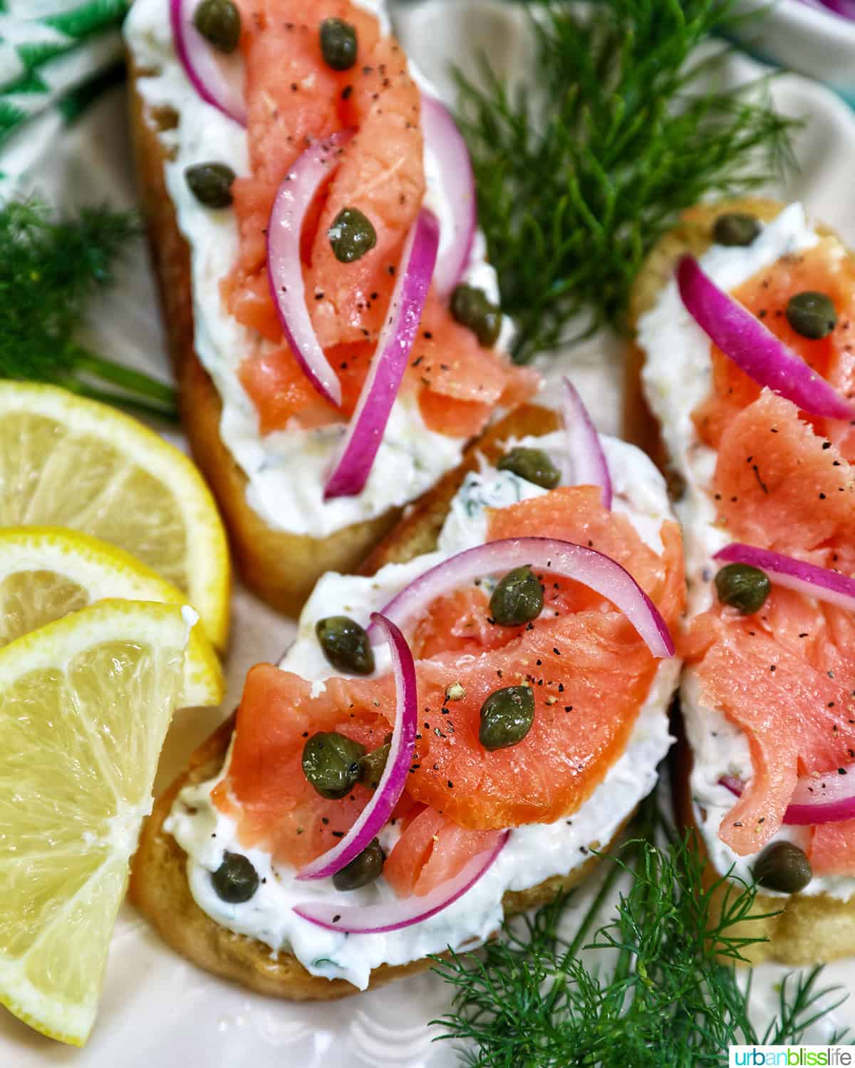 plate with three salmon crostini, and lemon wedges and dill sprigs as garnish.