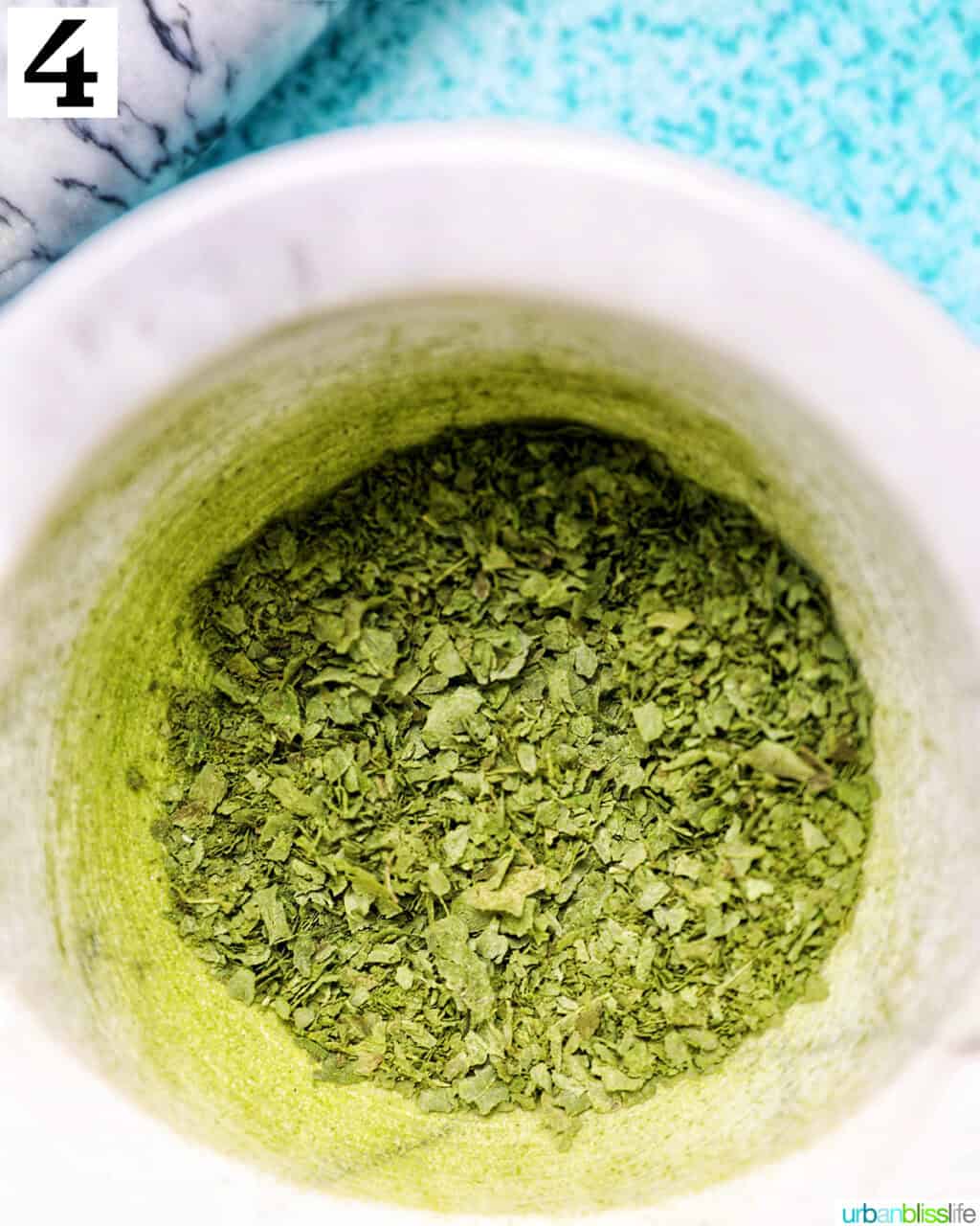 crushed dried oregano leaves in a marble bowl.