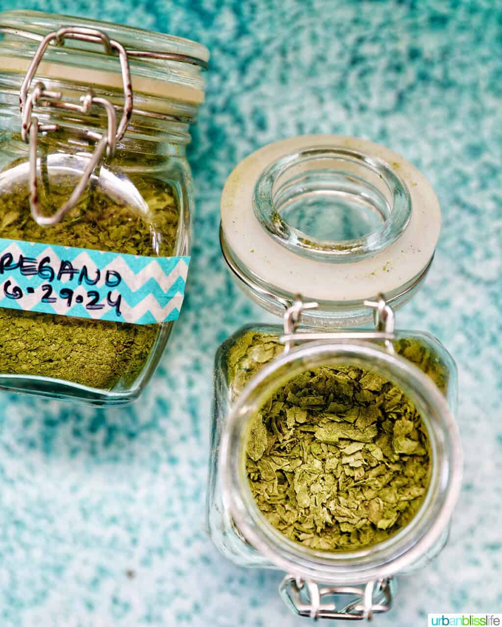 dried oregano in labeles jars with one jar open to reveal the leaves.