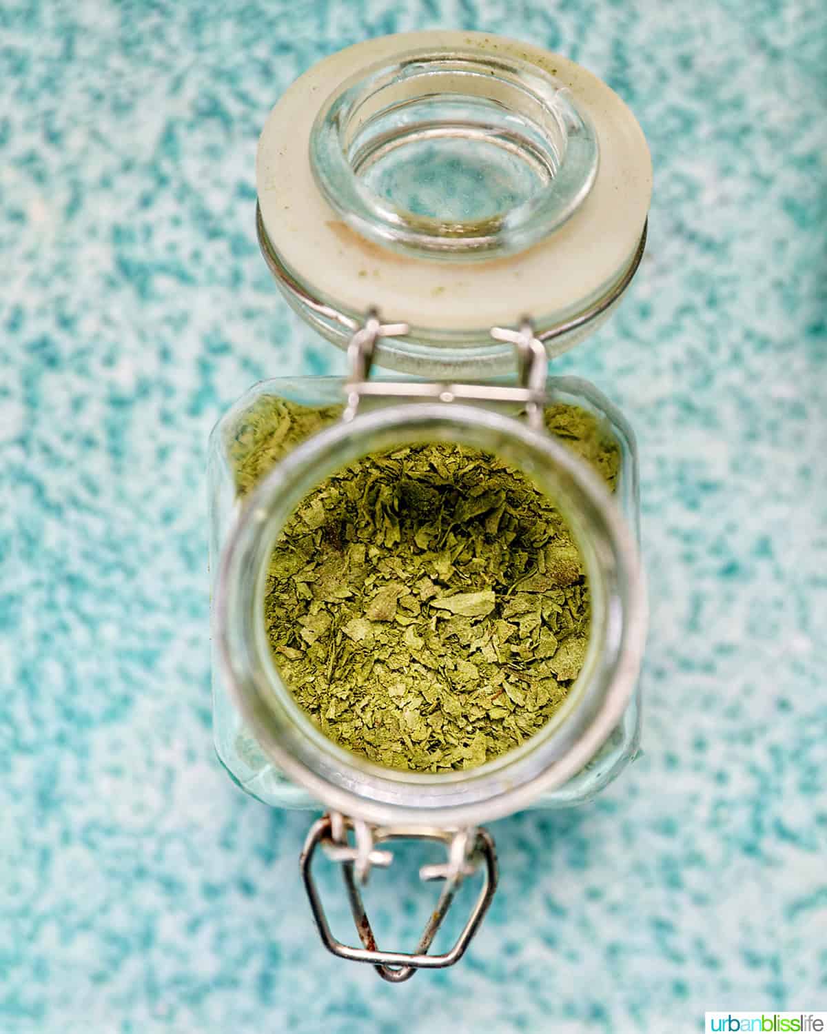 dried oregano leaves in an open mason jar.