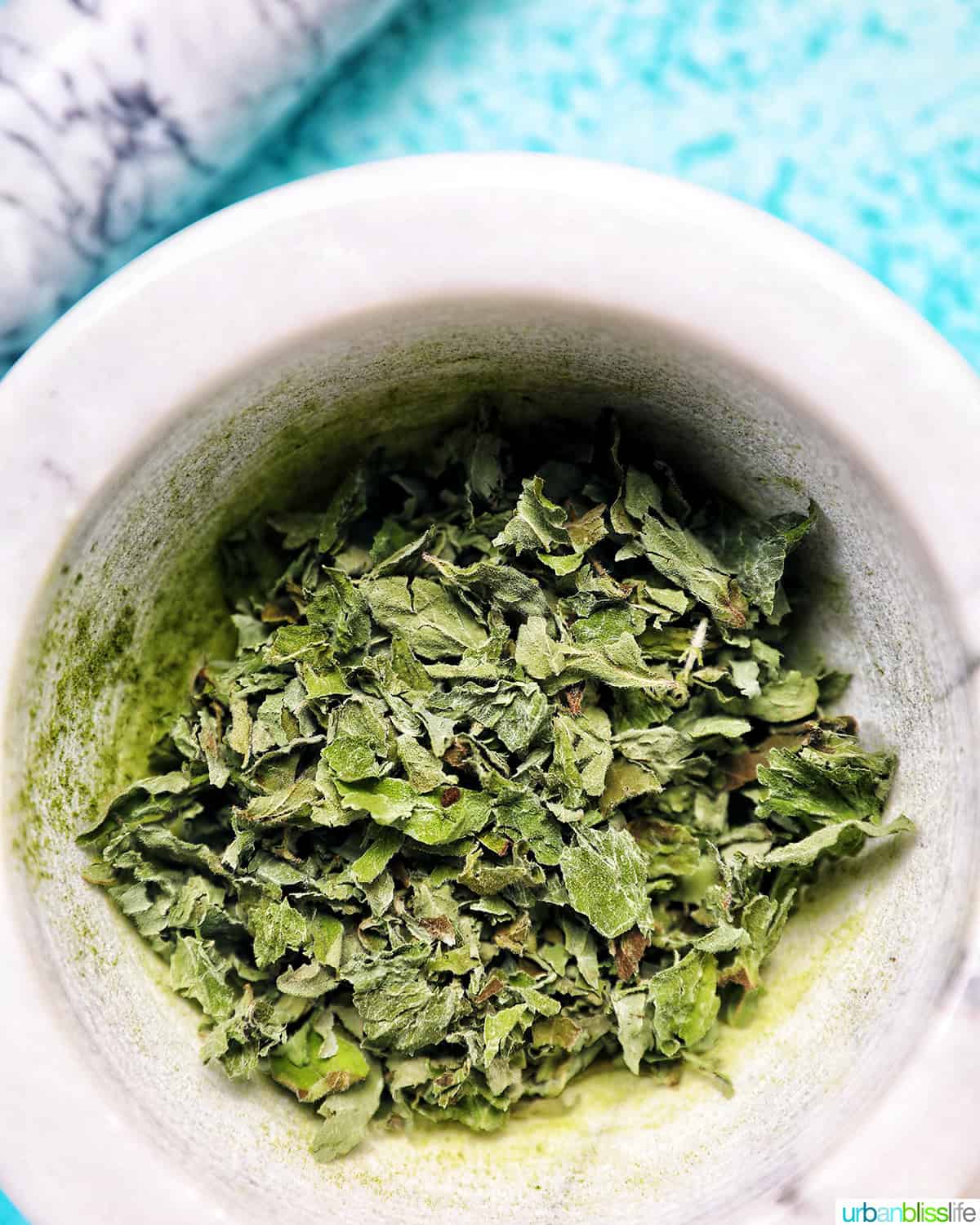 dried oregano leaves in a marble bowl.