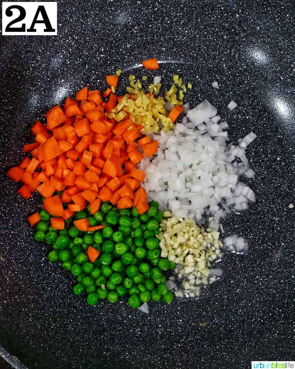carrots, peas, onions, and garlic in a wok.