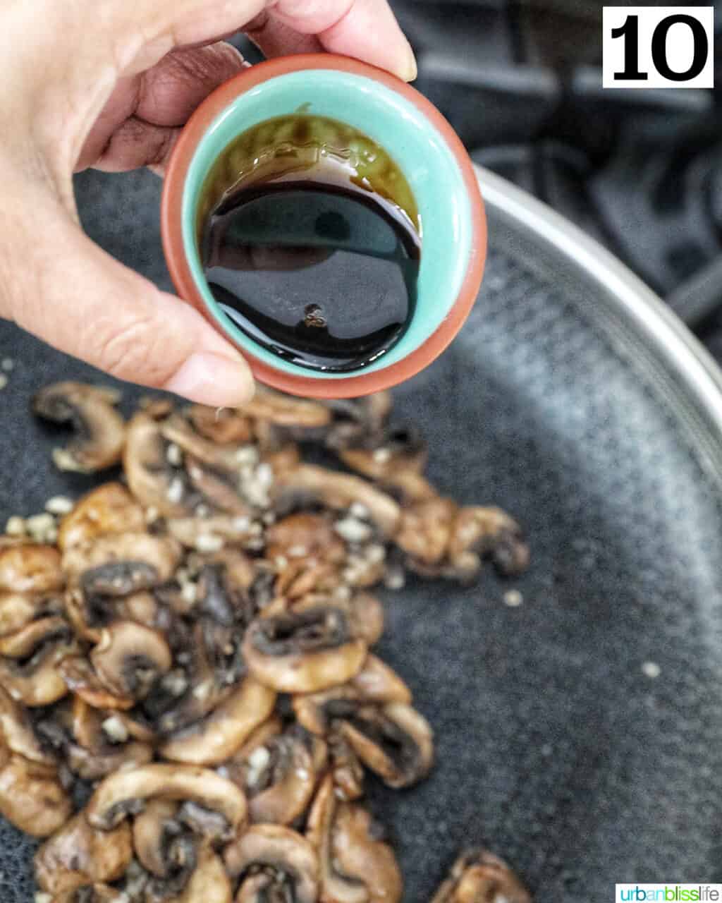 hand pouring a small bowl of balsamic glaze onto sliced mushrooms in a cast iron skillet.