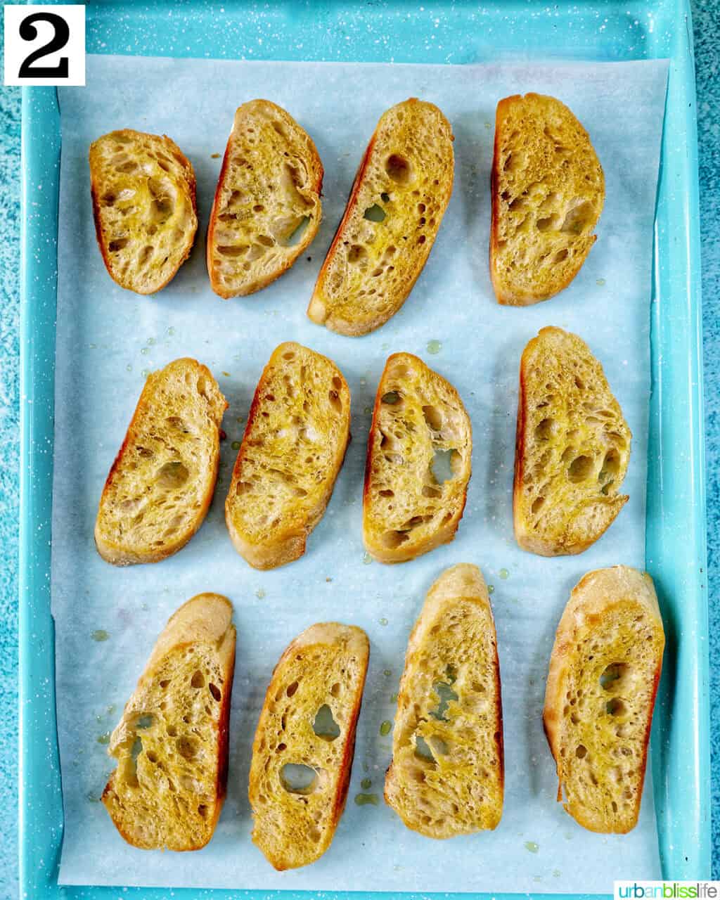 sliced baguette with olive oil on a baking sheet.