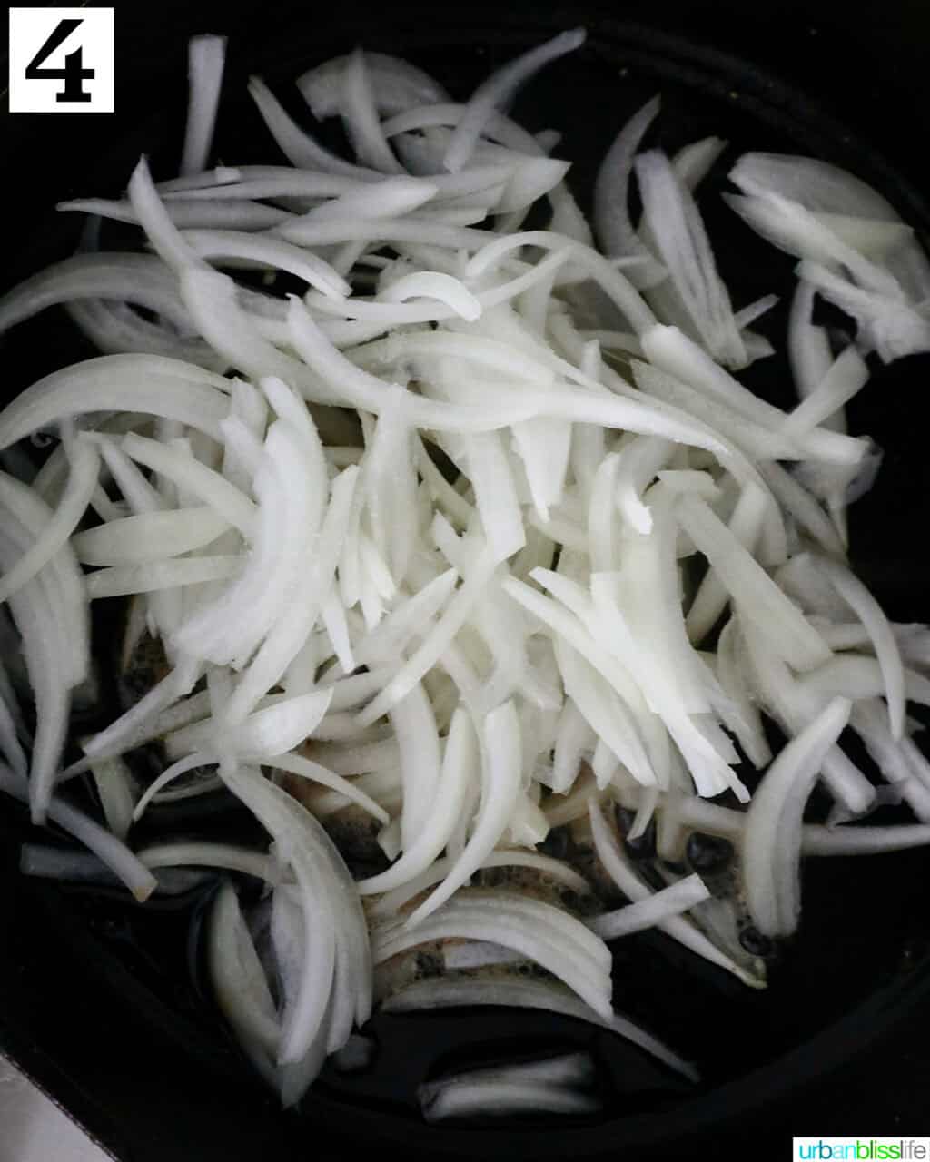 sliced onions in a cast iron skillet.