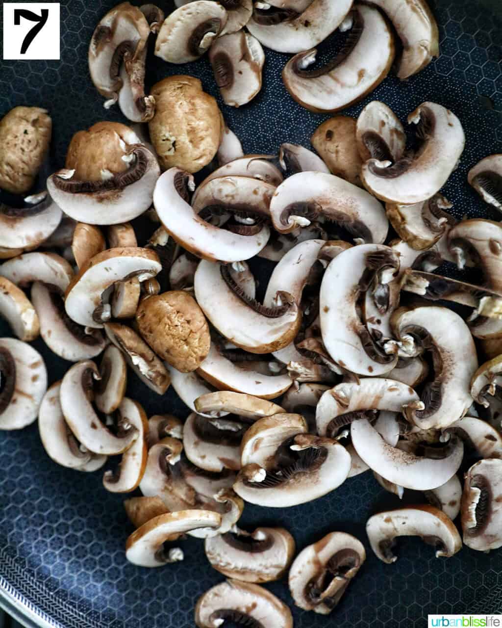 sliced mushrooms in a cast iron skillet.