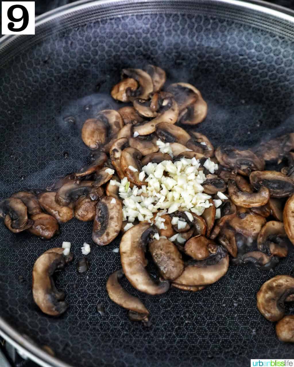 garlic added to cooked sliced mushrooms in a cast iron skillet.
