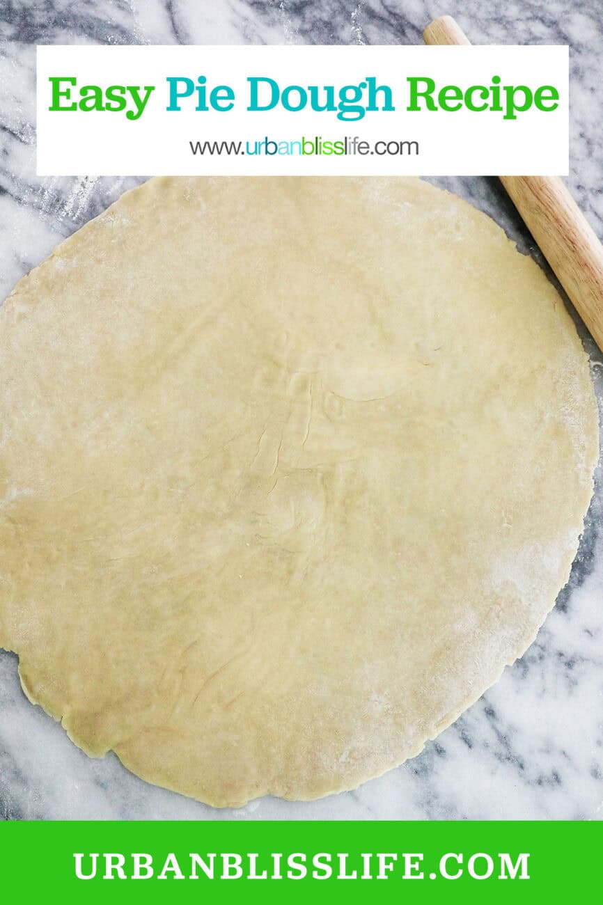 rolled out pie on marble next to a rolling pin.