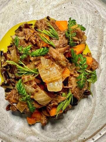 beef and vegetables on a speckled plate.