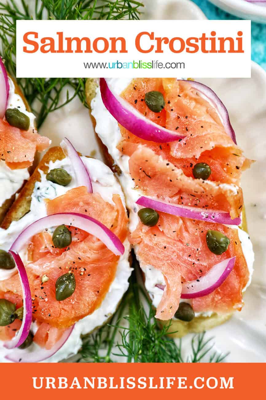 crostini al salmone with garnish of dill on a scalloped plate.
