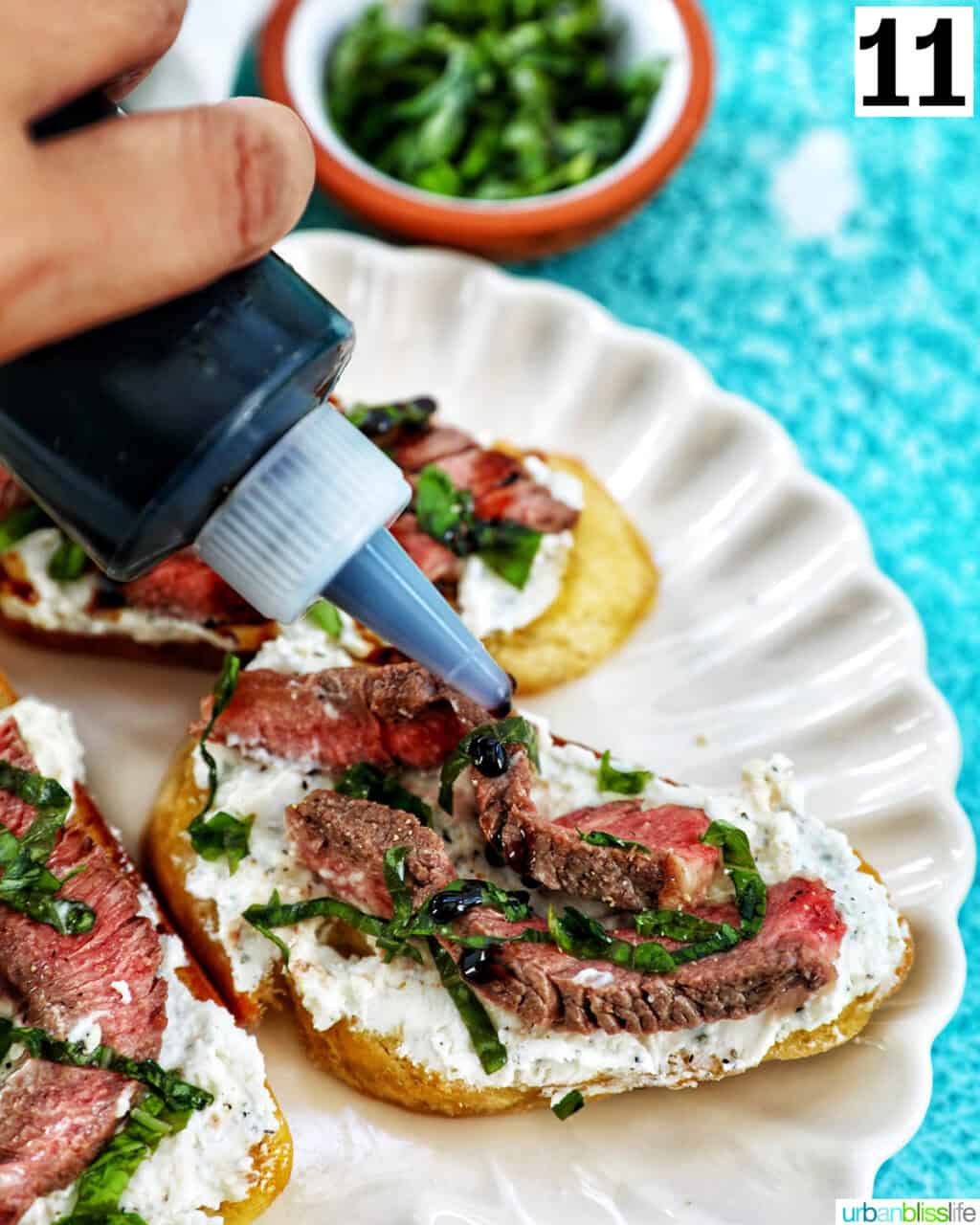 hand drizzling balsamic glaze onto steak crostini.