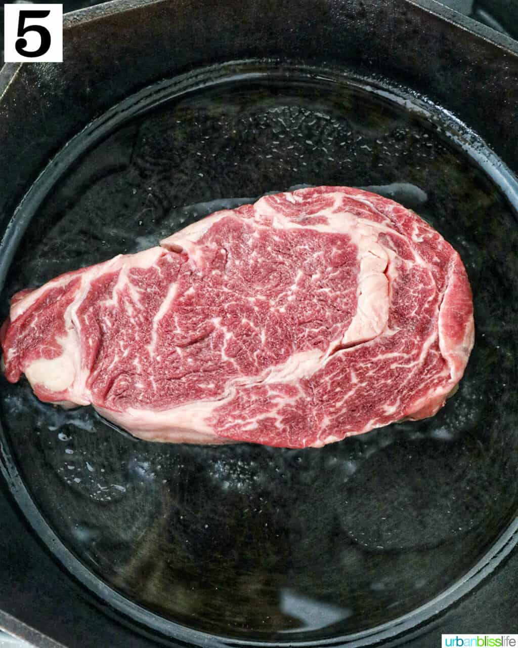 raw steak in a cast iron skillet.