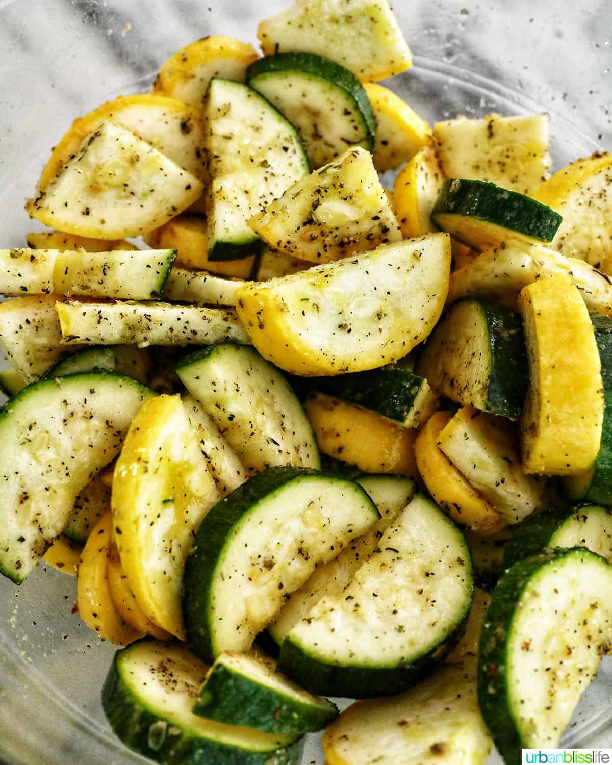 white bowl with air fryer zucchini and yellow squash.