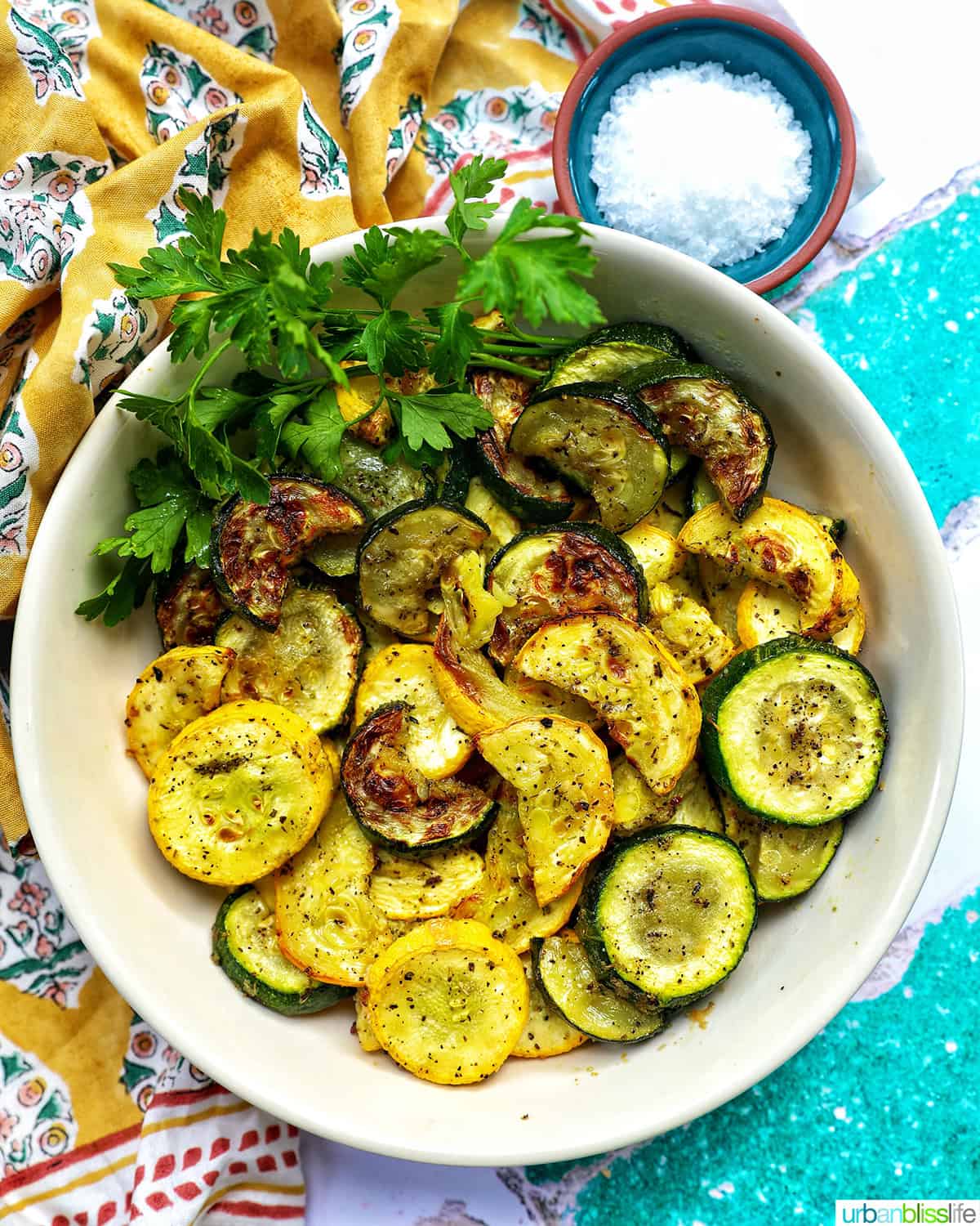 white bowl with air fryer zucchini and yellow squash.