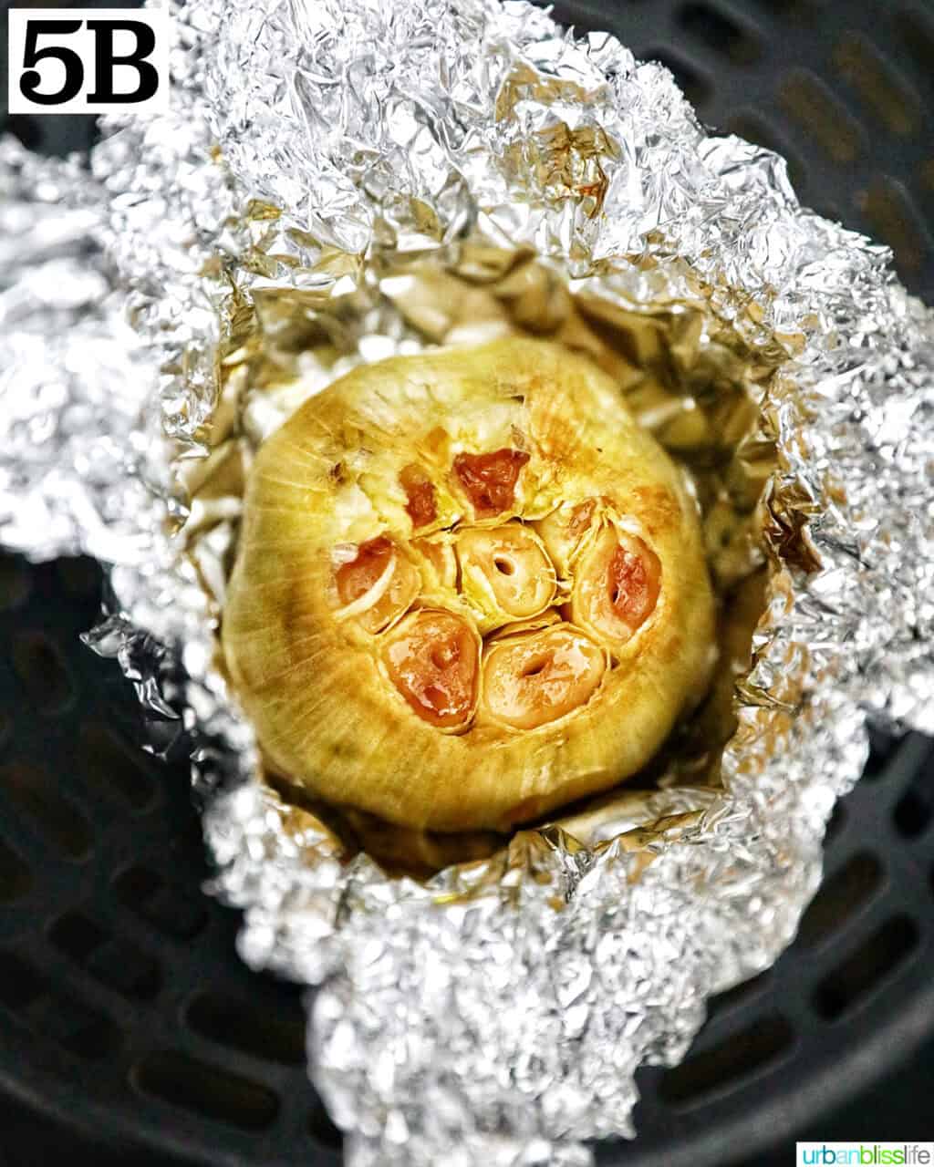 aluminum foil open to roasted garlic head.