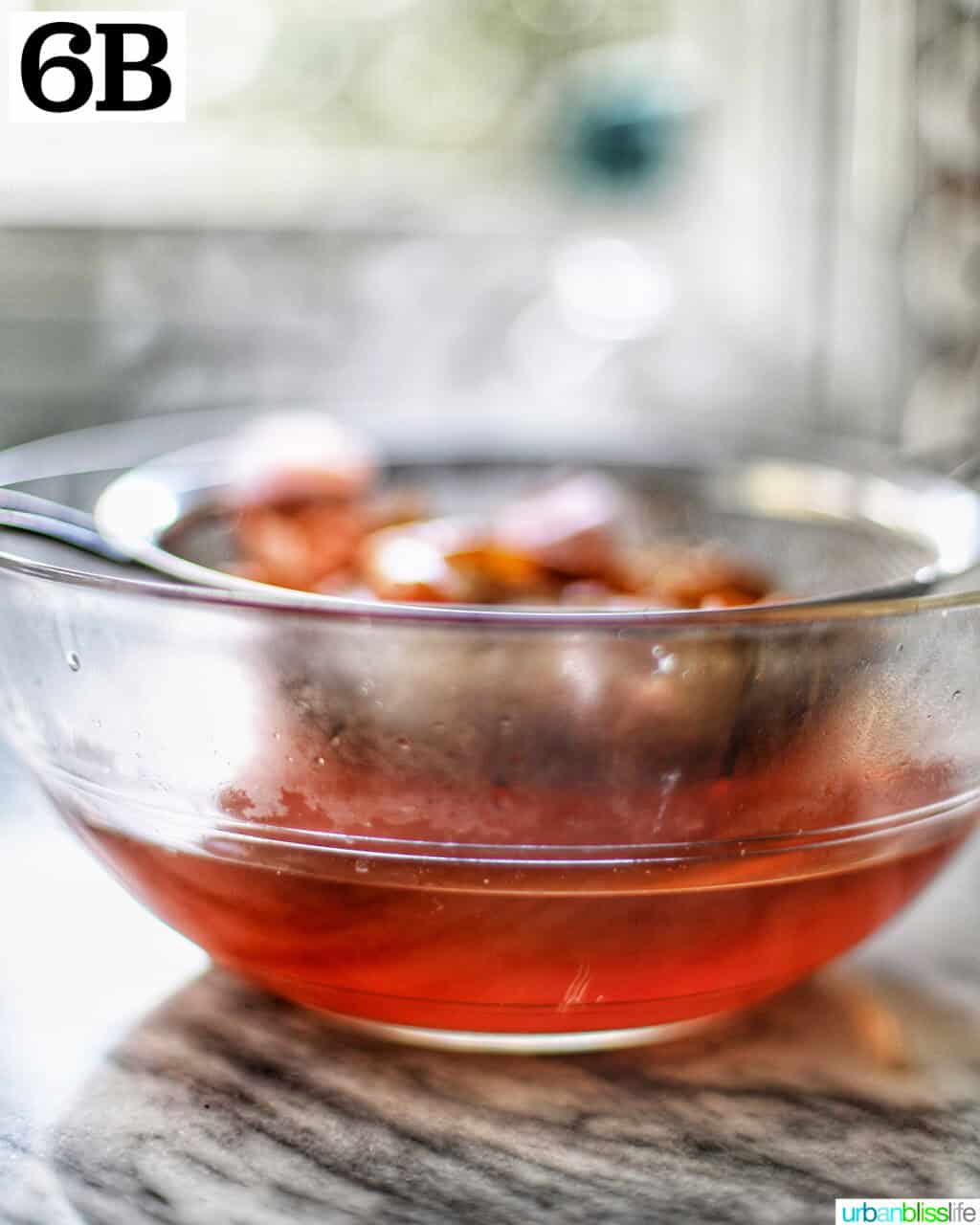 seafood stock strained in a glass bowl.