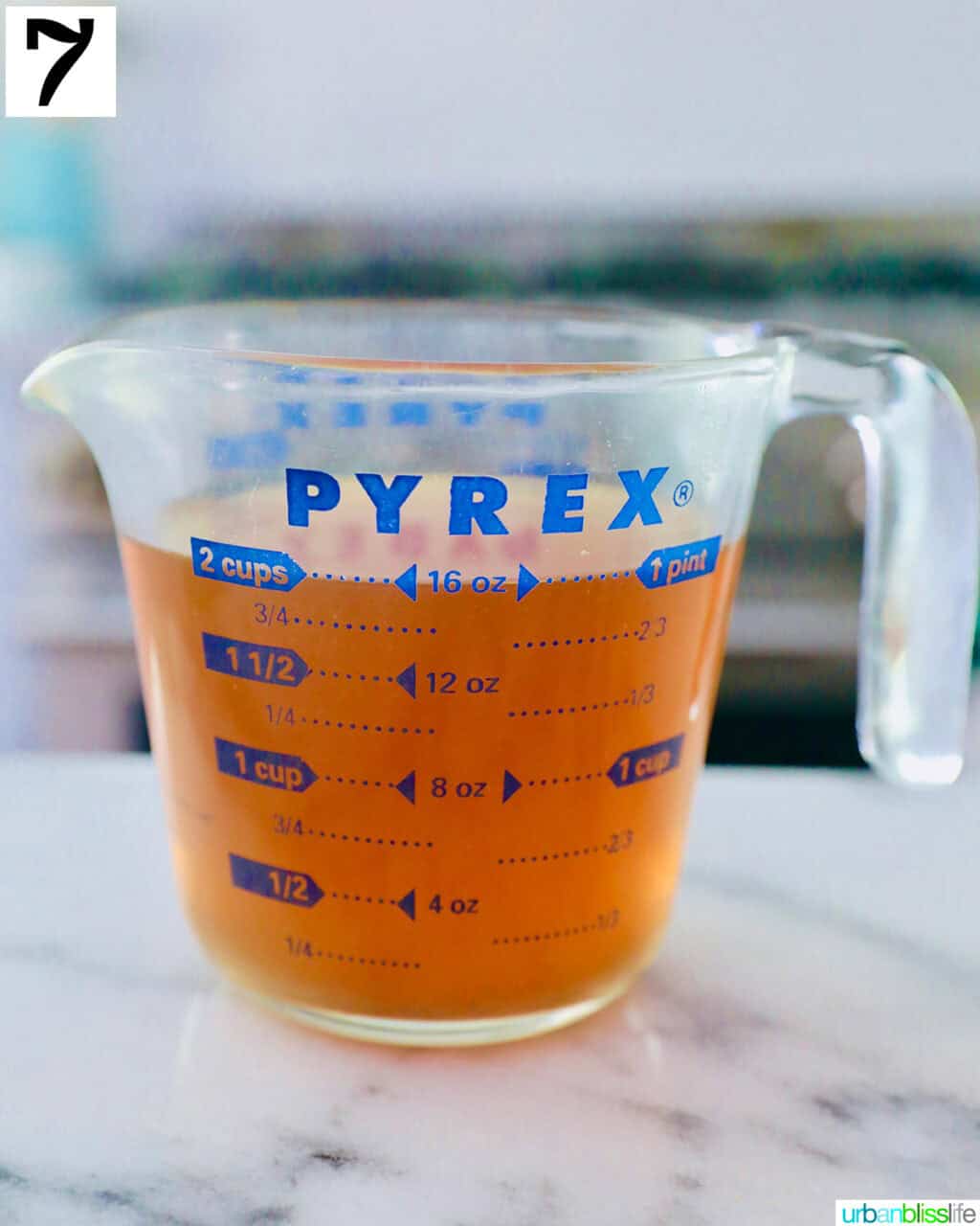 seafood stock in a measuring cup with spout.