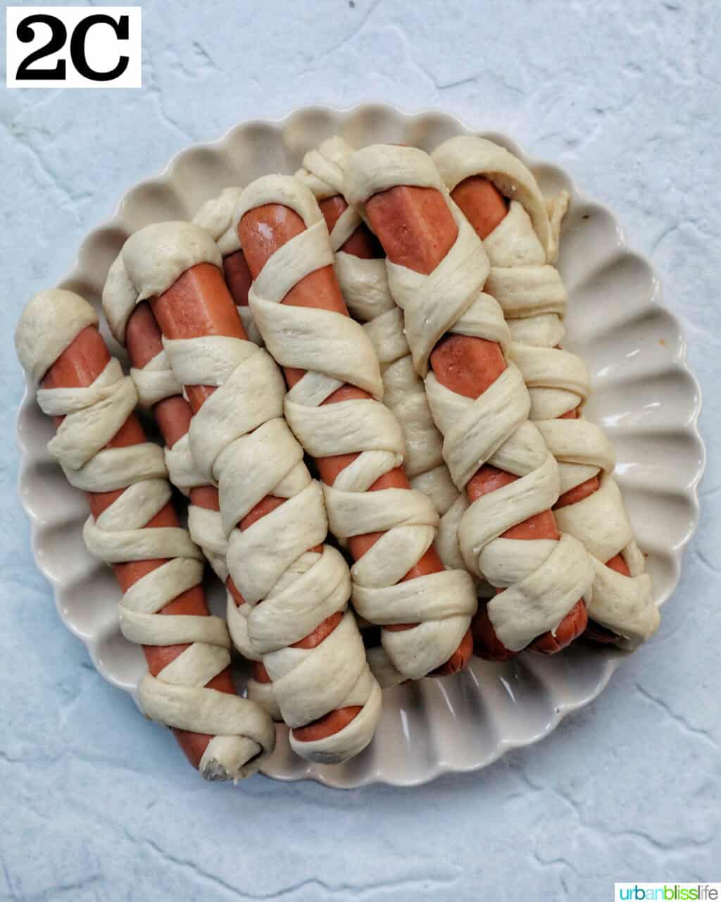 assembled mummy dogs stacked on a plate.