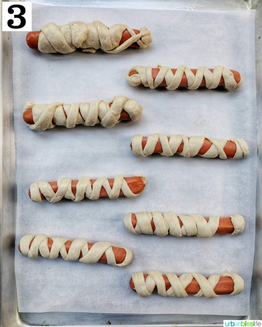 mummy dogs on a baking sheet ready to bake.