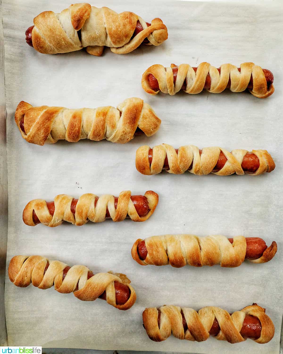 baked mummy hot dogs on a baking sheet.