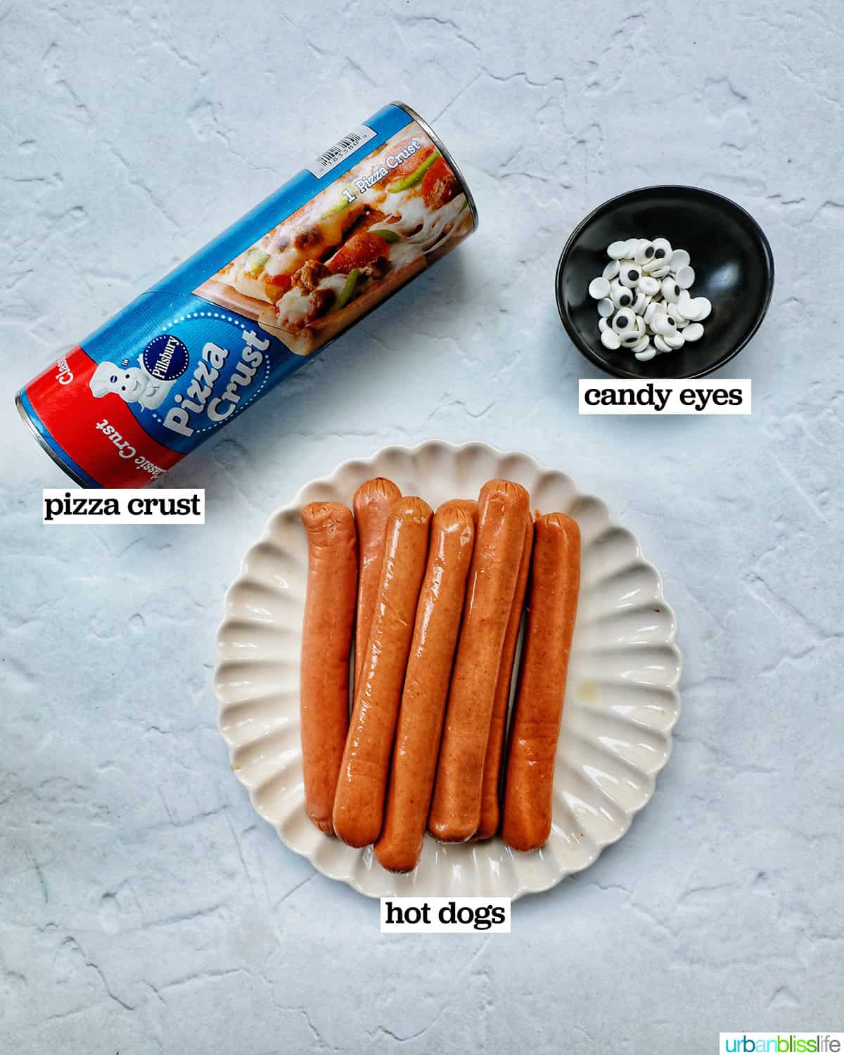 ingredients to make mummy dogs: hot dogs, pizza dough,and candy eyes.