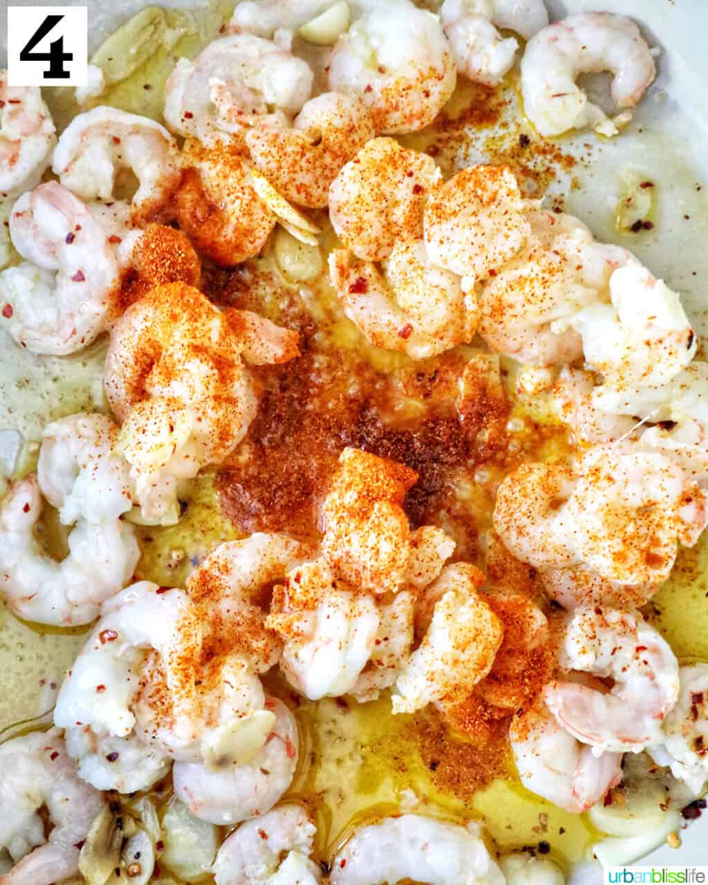 paprika added to shrimp in a pan.