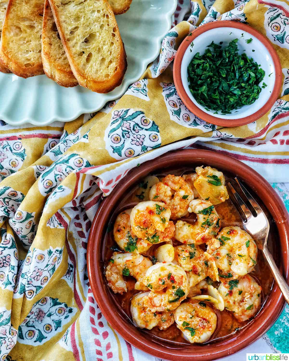 spanish prawns with side of sliced baguette and chopped parsley.
