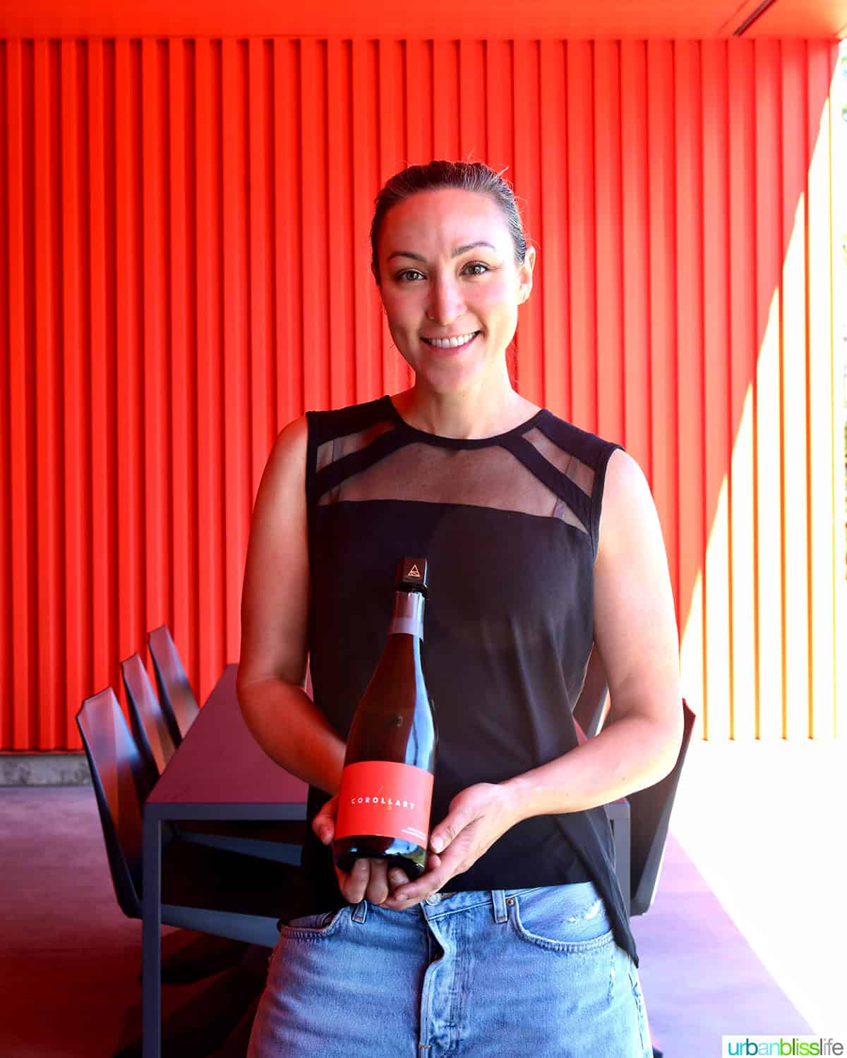 corollary wines co-owner jeanne feldkamp holding a bottle of sparkling wine