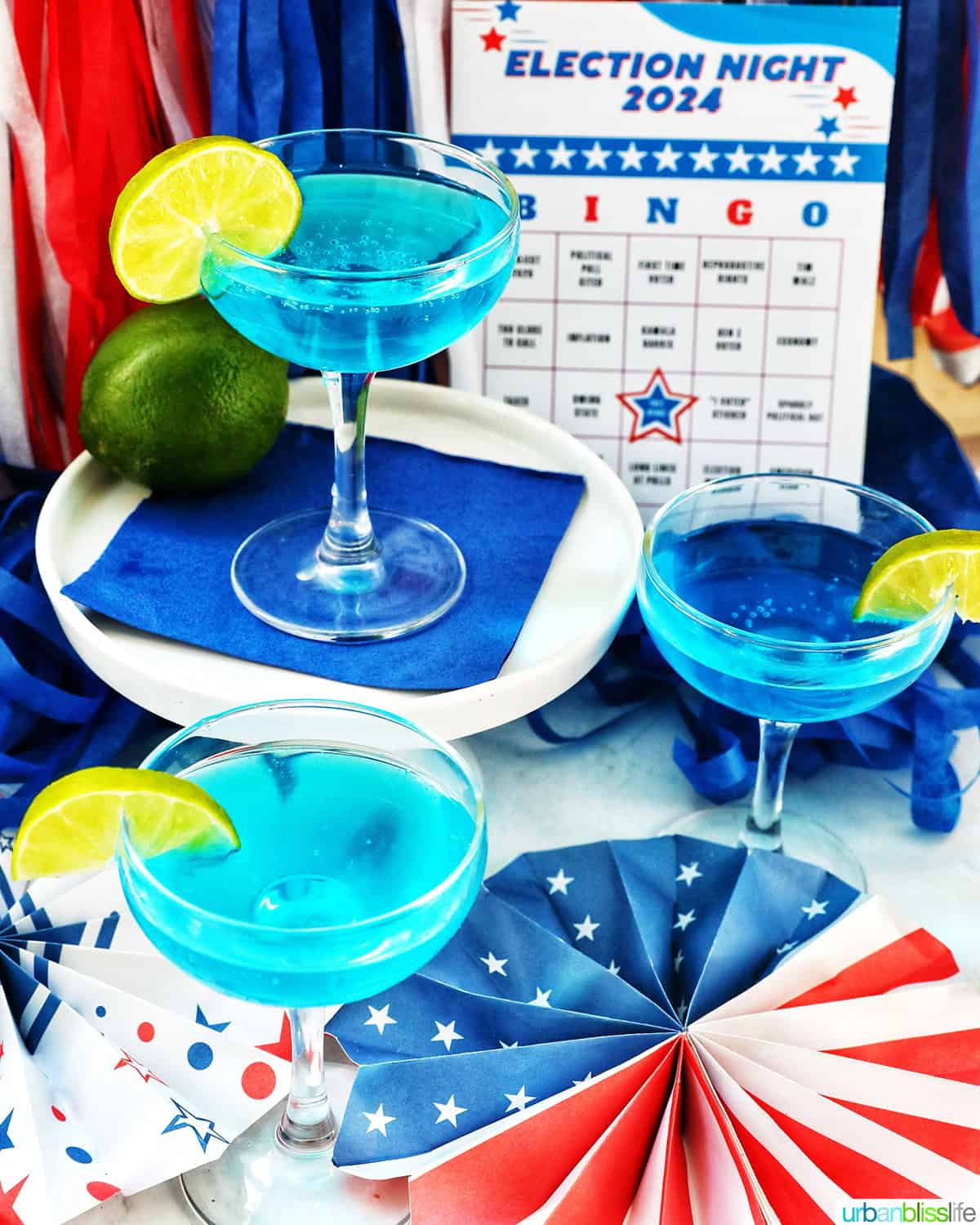 three glasses of blue wave cocktails with red, white and blue election party decorations.