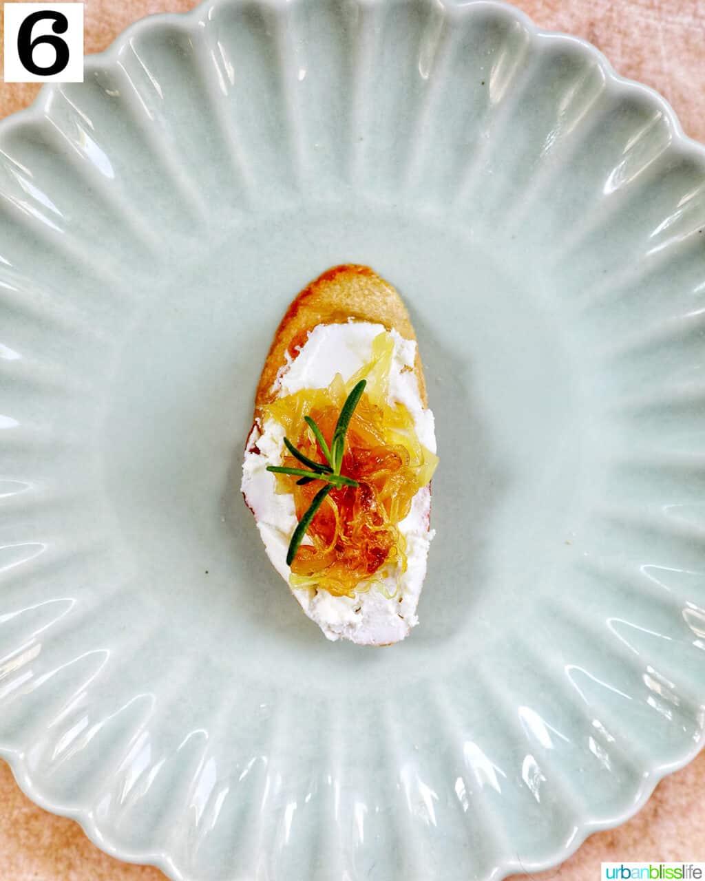 caramelized onions and goat cheese crostini slice on a green plate.