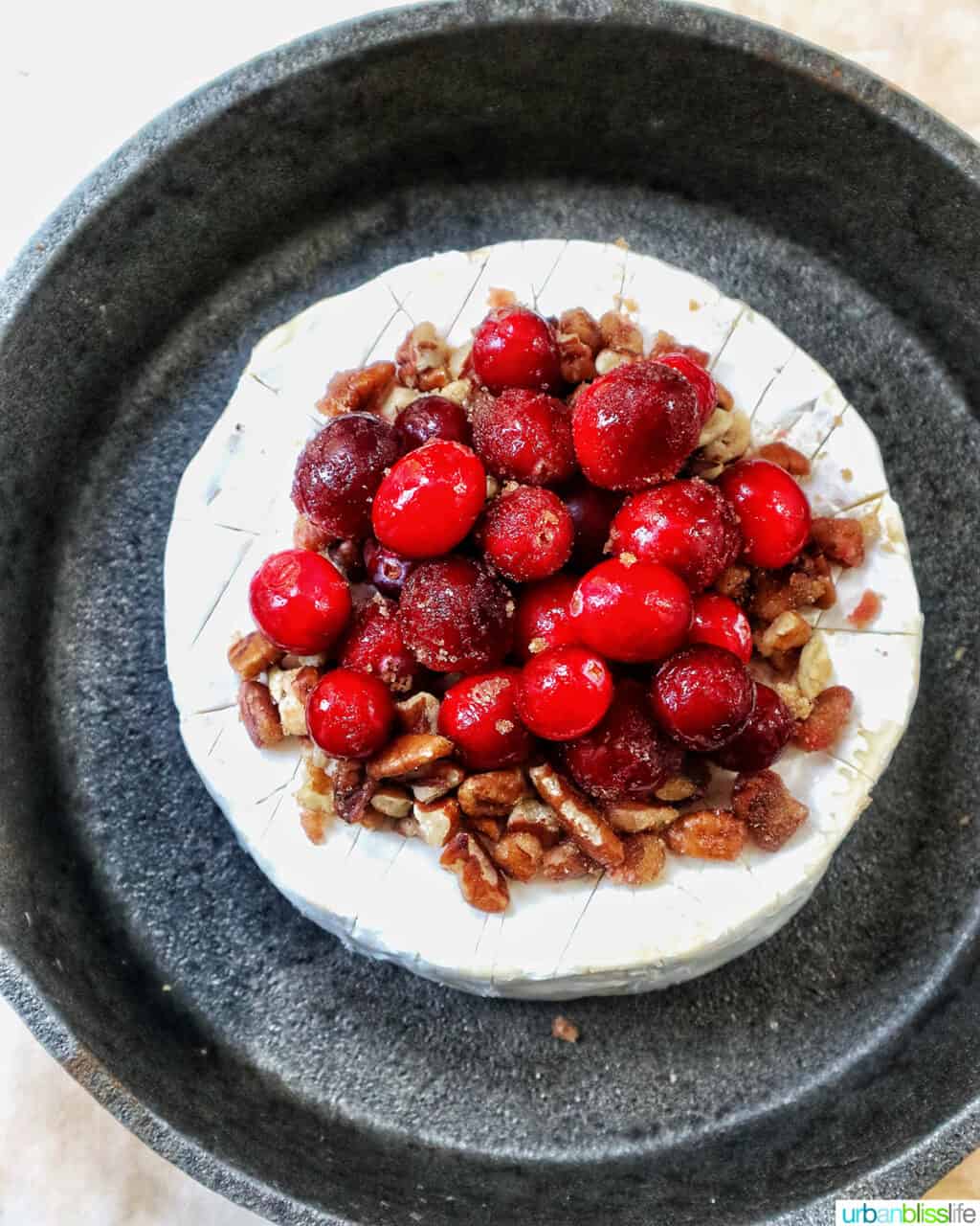 cranberry pecan baked brie in a skillet.