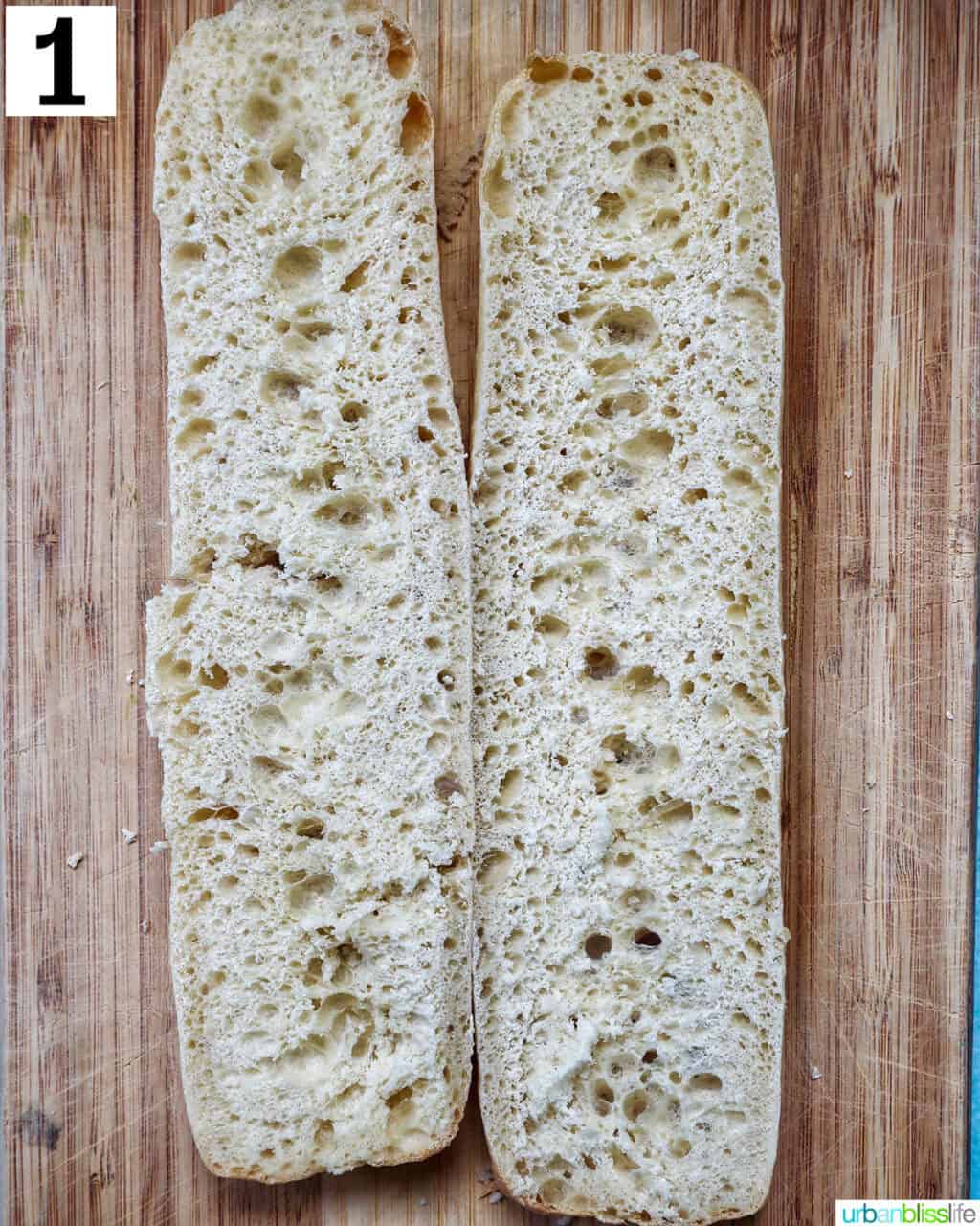baguette sliced in half on a cutting board.