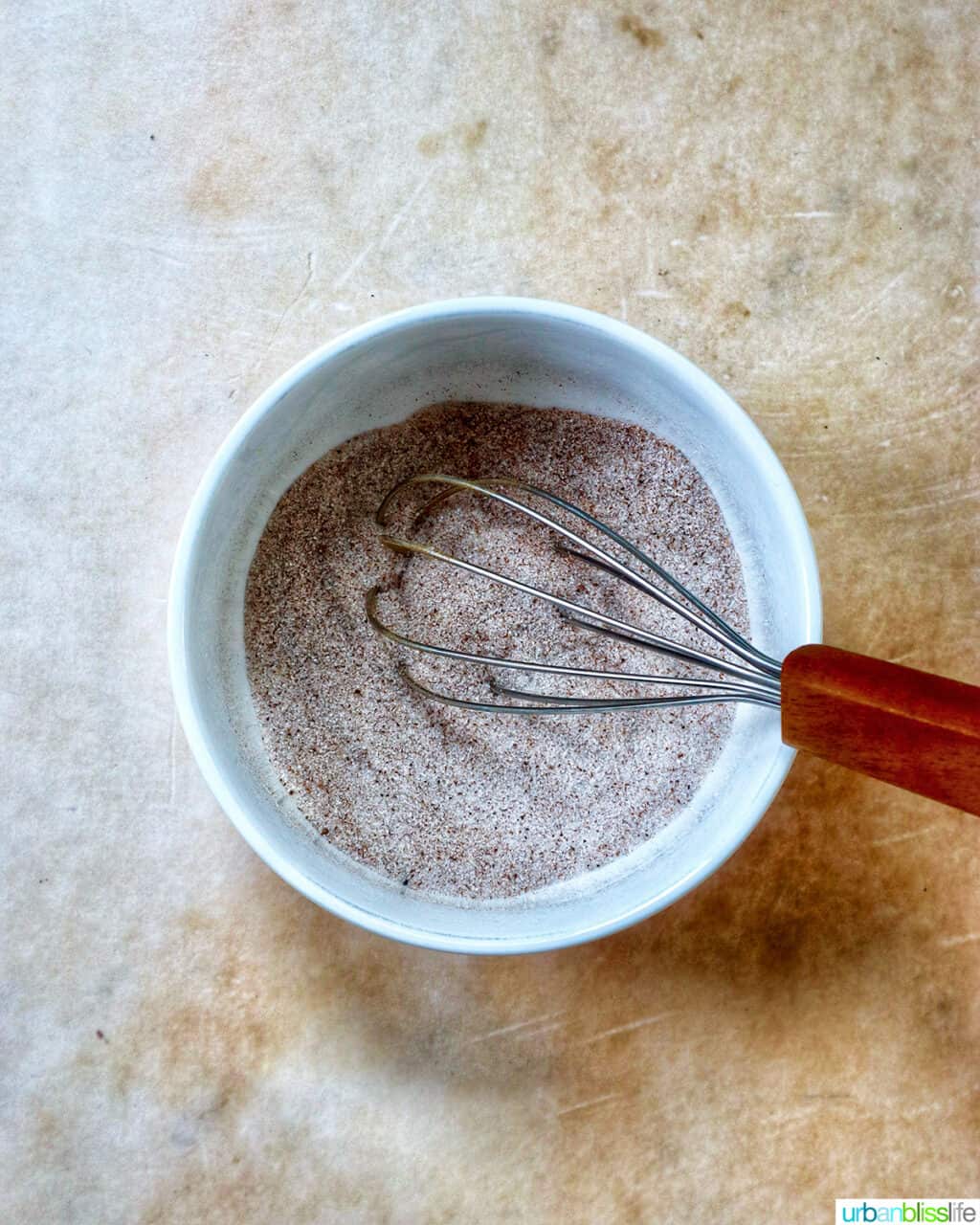 whisk with cinnamon sugar in a white bowl.