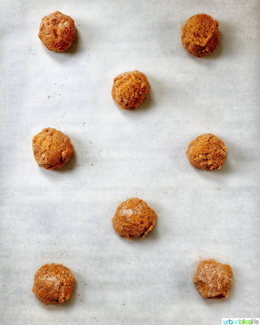 pumpkin pie spice cookie dough balls on a baking sheet.