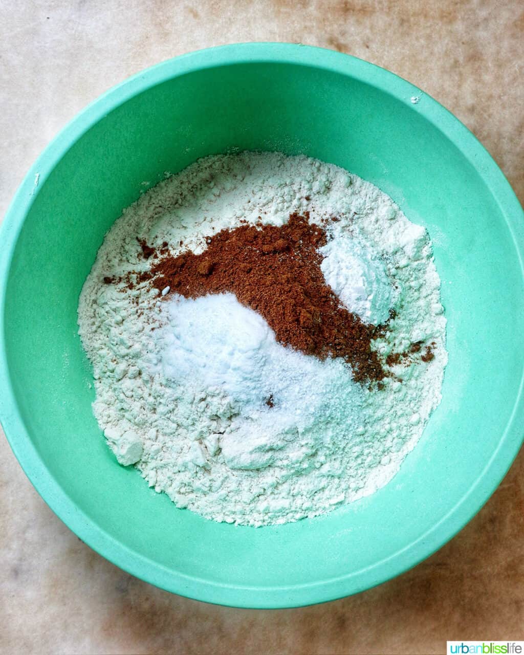 dry ingredients to make pumpkin spice cookies in a green bowl.