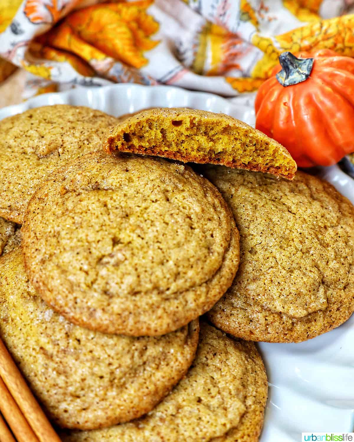 plate full of pumpkin spice cookies with pumpkin decorations and cinnamon sticks.