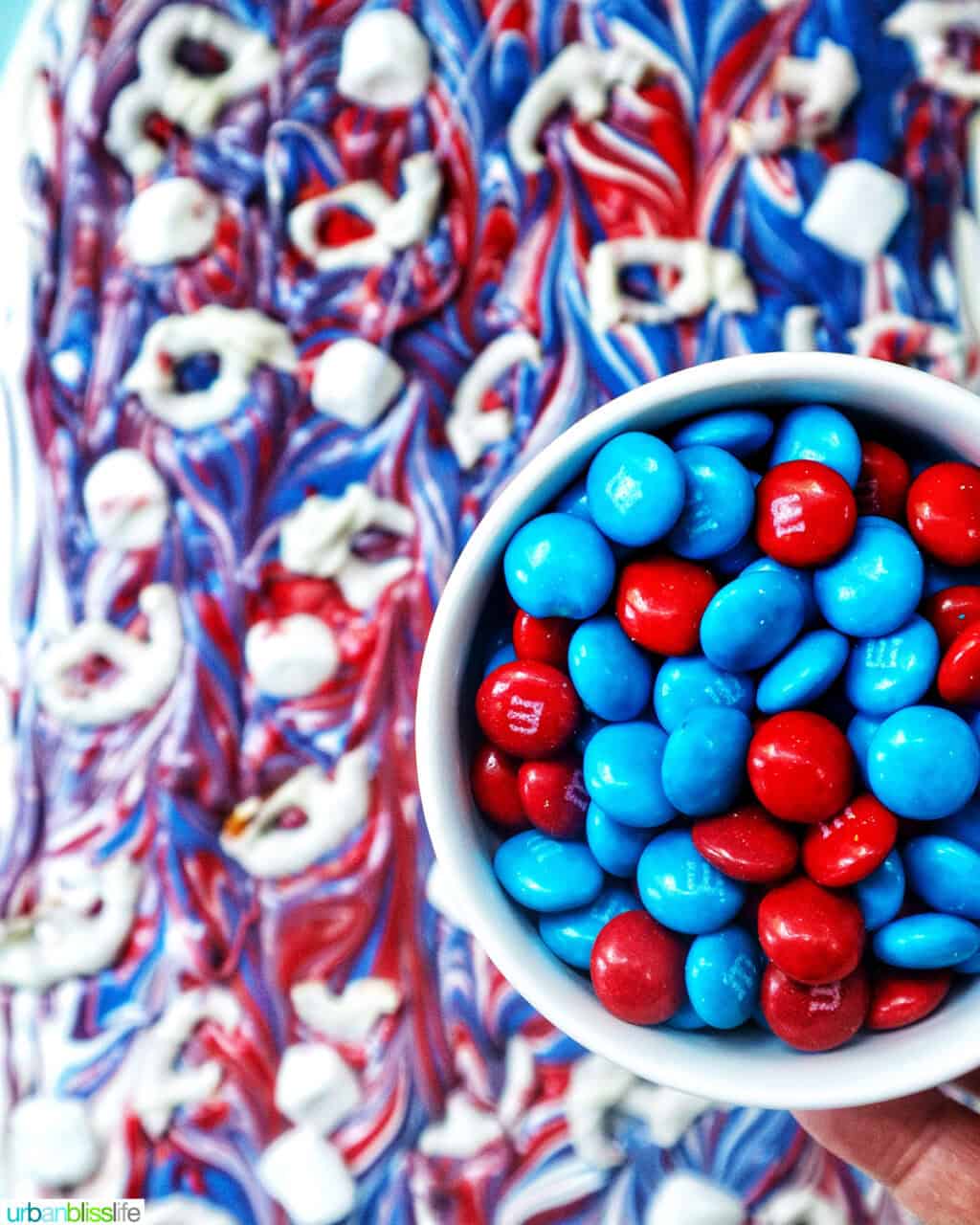 bowl of red and blue M & Ms over red, white, and blue chocolate bark.
