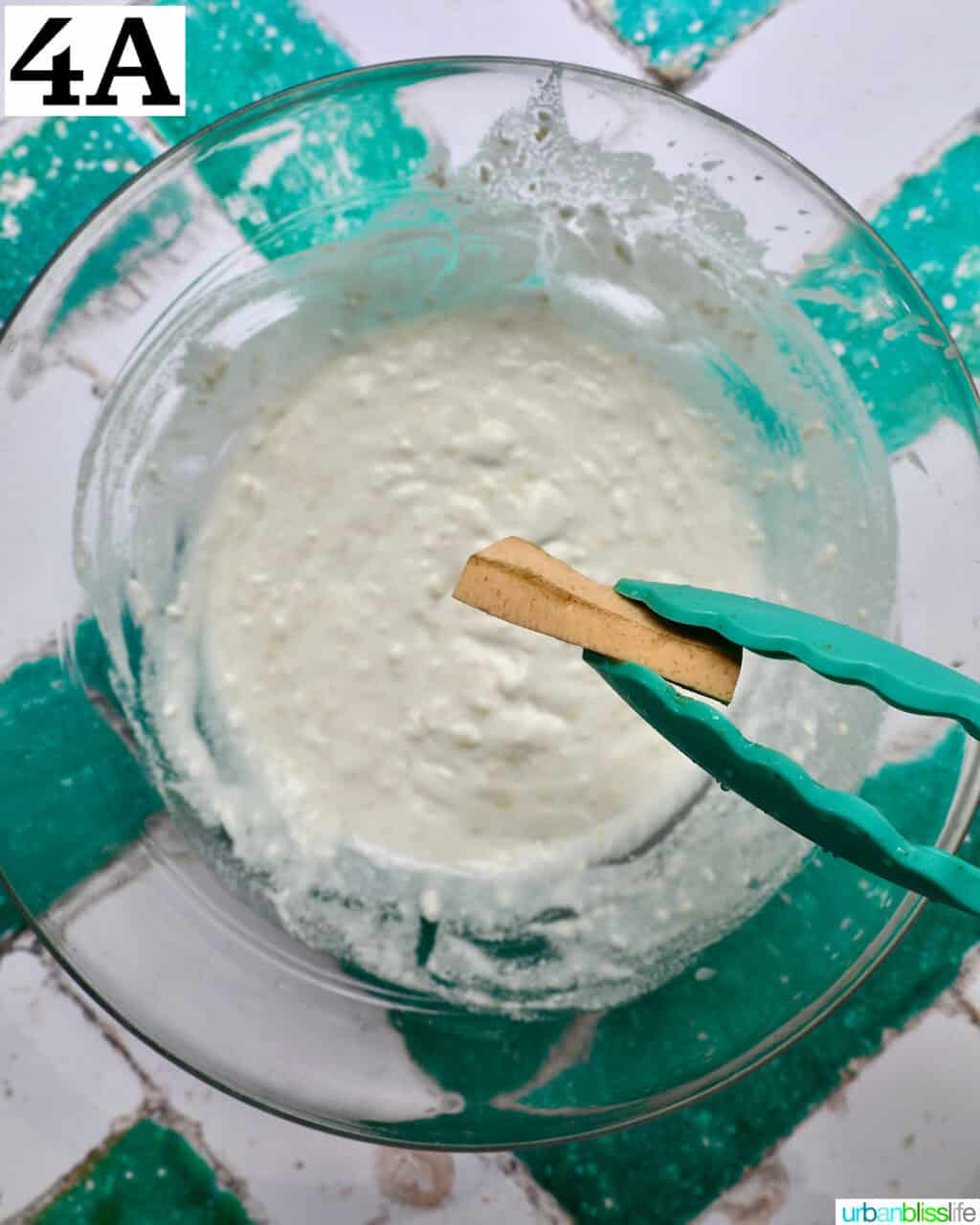 tongs holding a plantain over batter.