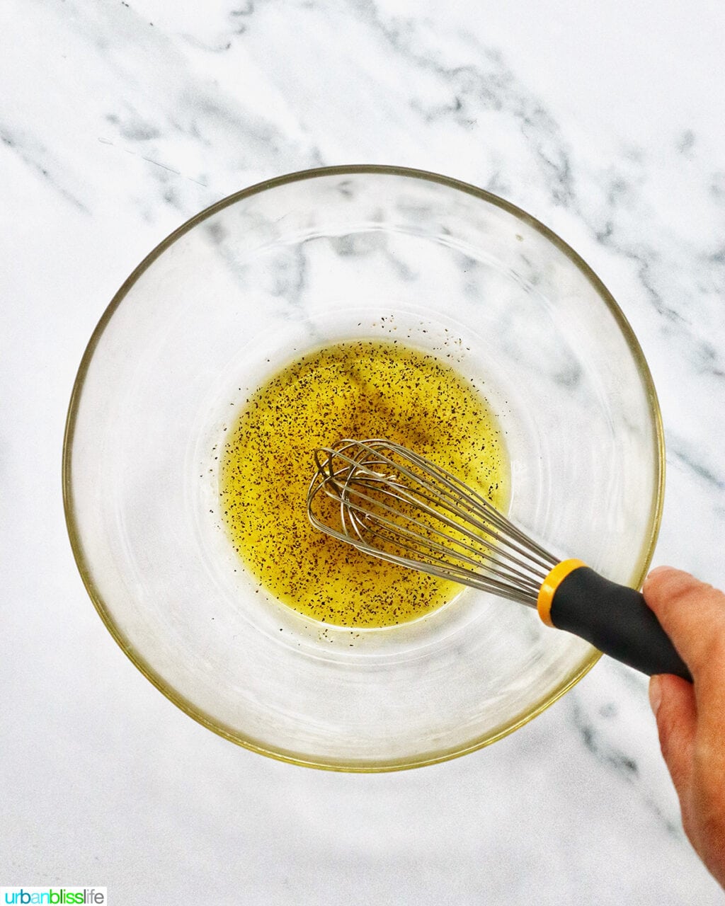whisking olive oil and vinegar.