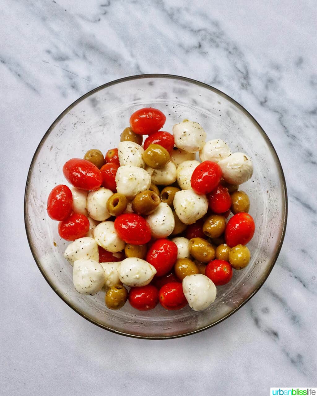 bowl with tomatoes, mozzarella balls, and olives.
