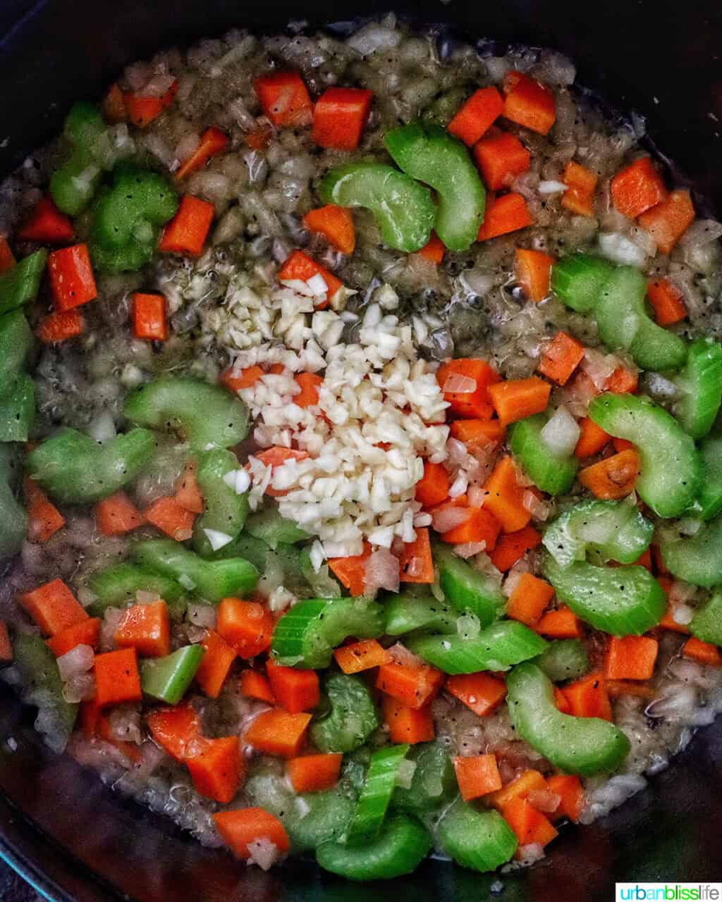 garlic added to mirepoix of carrots, celery, and onions in a Dutch oven.
