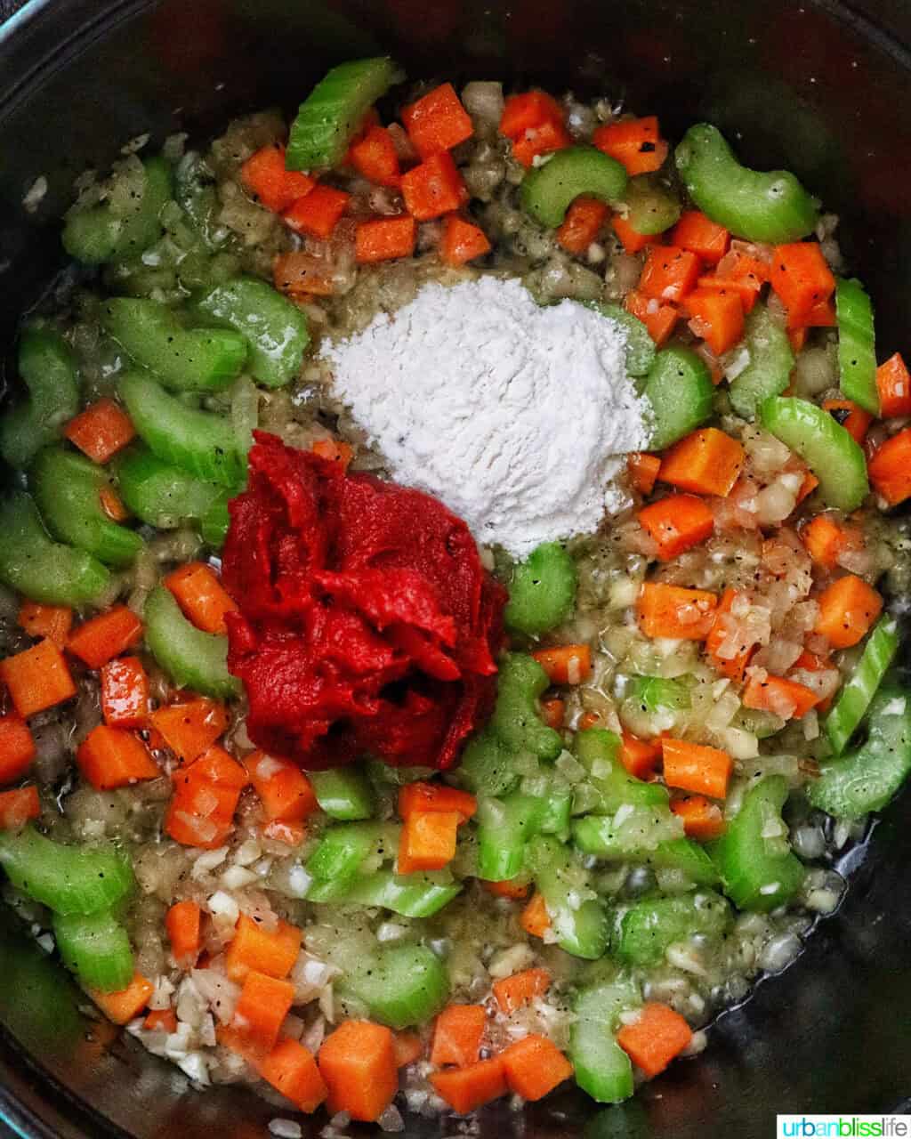 tomato paste and flour added to mirepoix of carrots, celery, and onions in a Dutch oven.