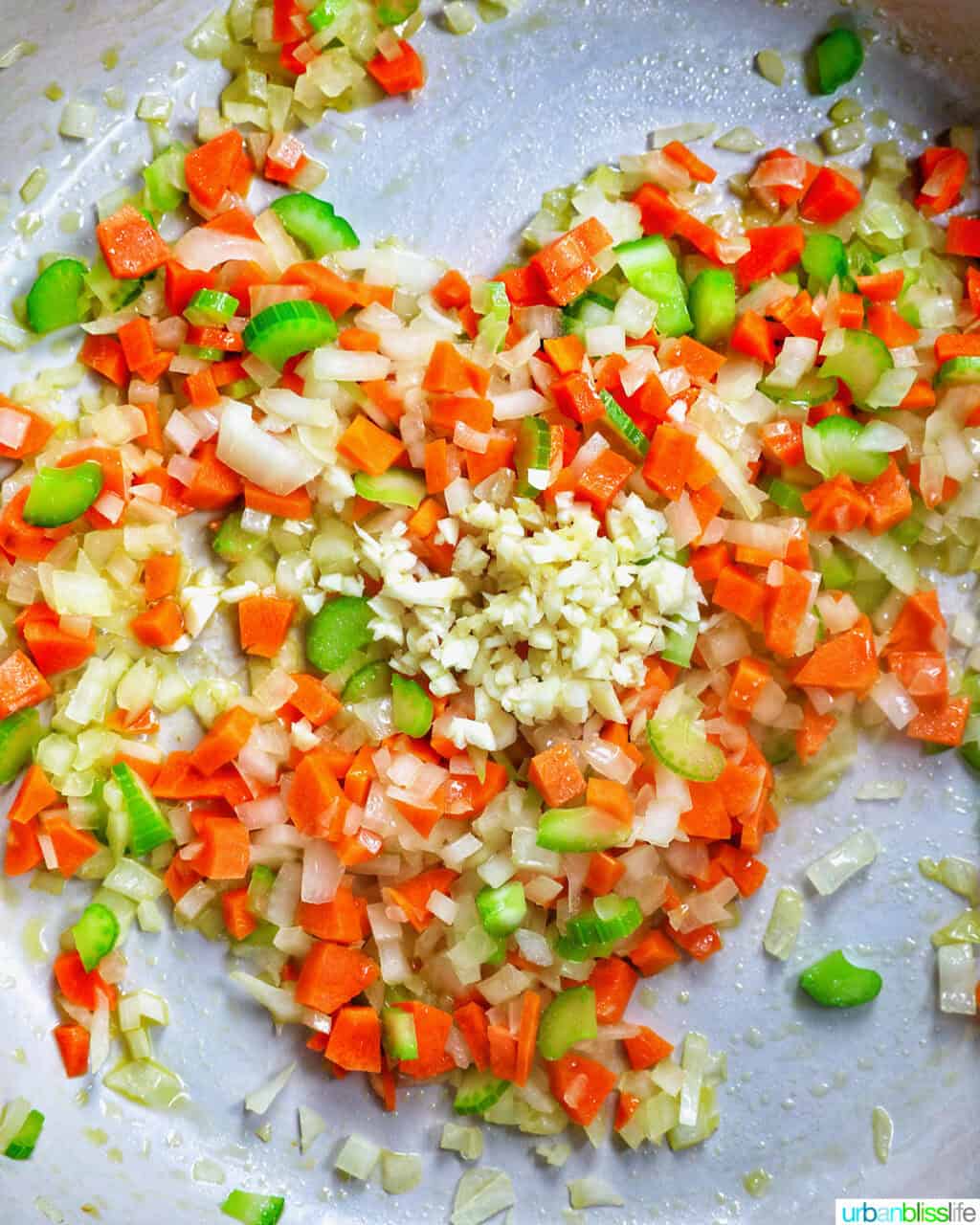 carrots, onions, celery cooking in a pan.
