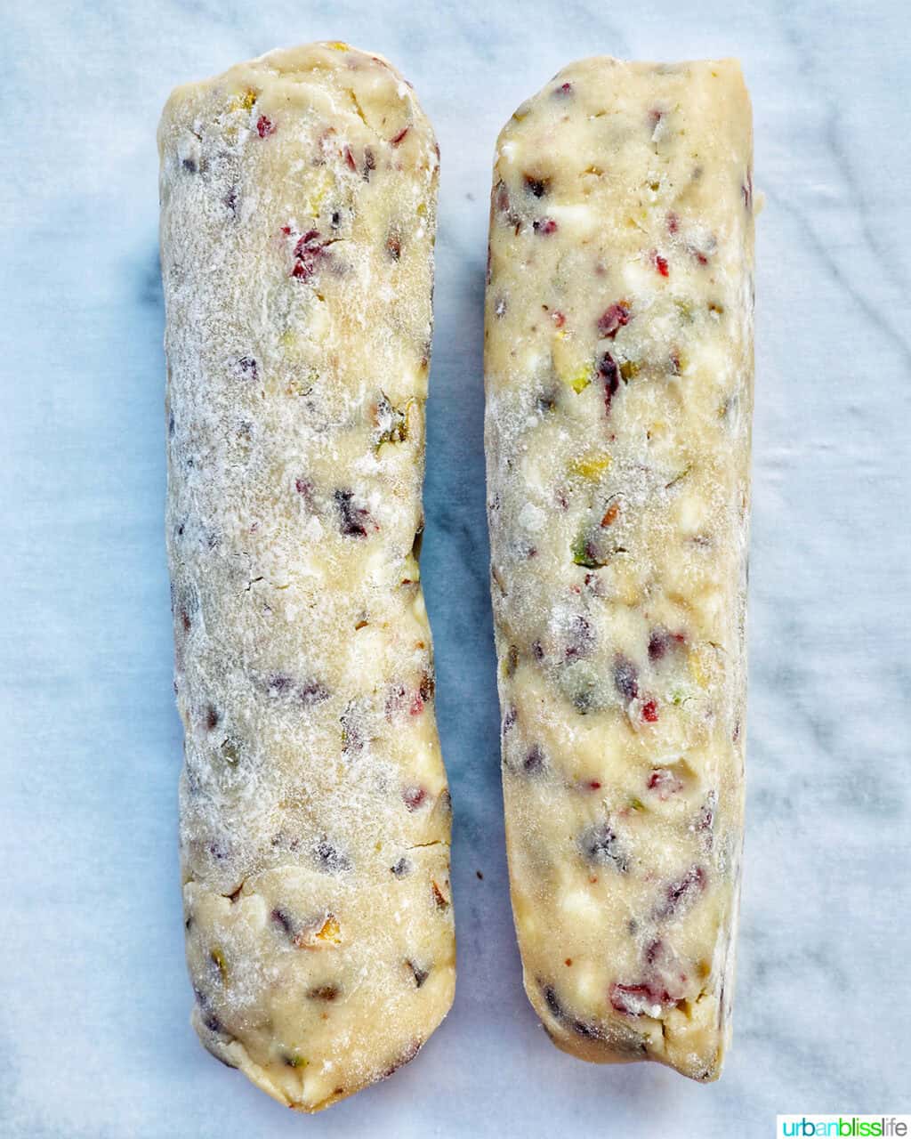 pistachio cranberry shortbread cookie dough rolled into two dough logs.